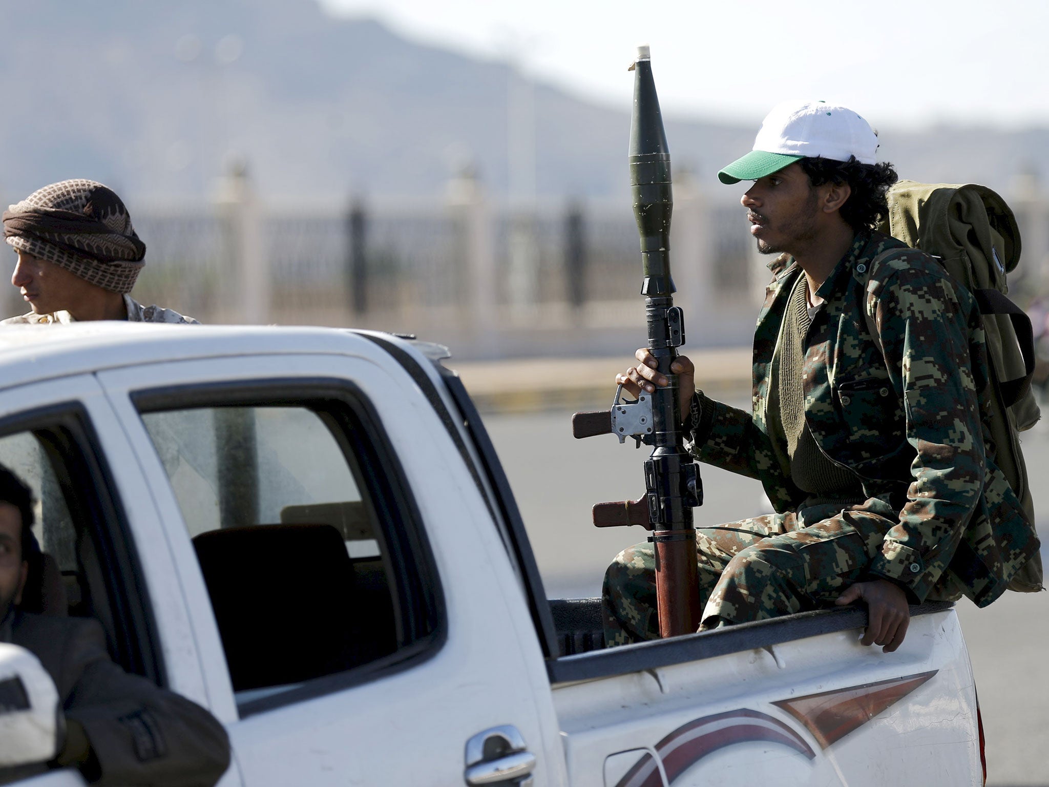 Houthi fighters ride a patrol truck in Sanaa