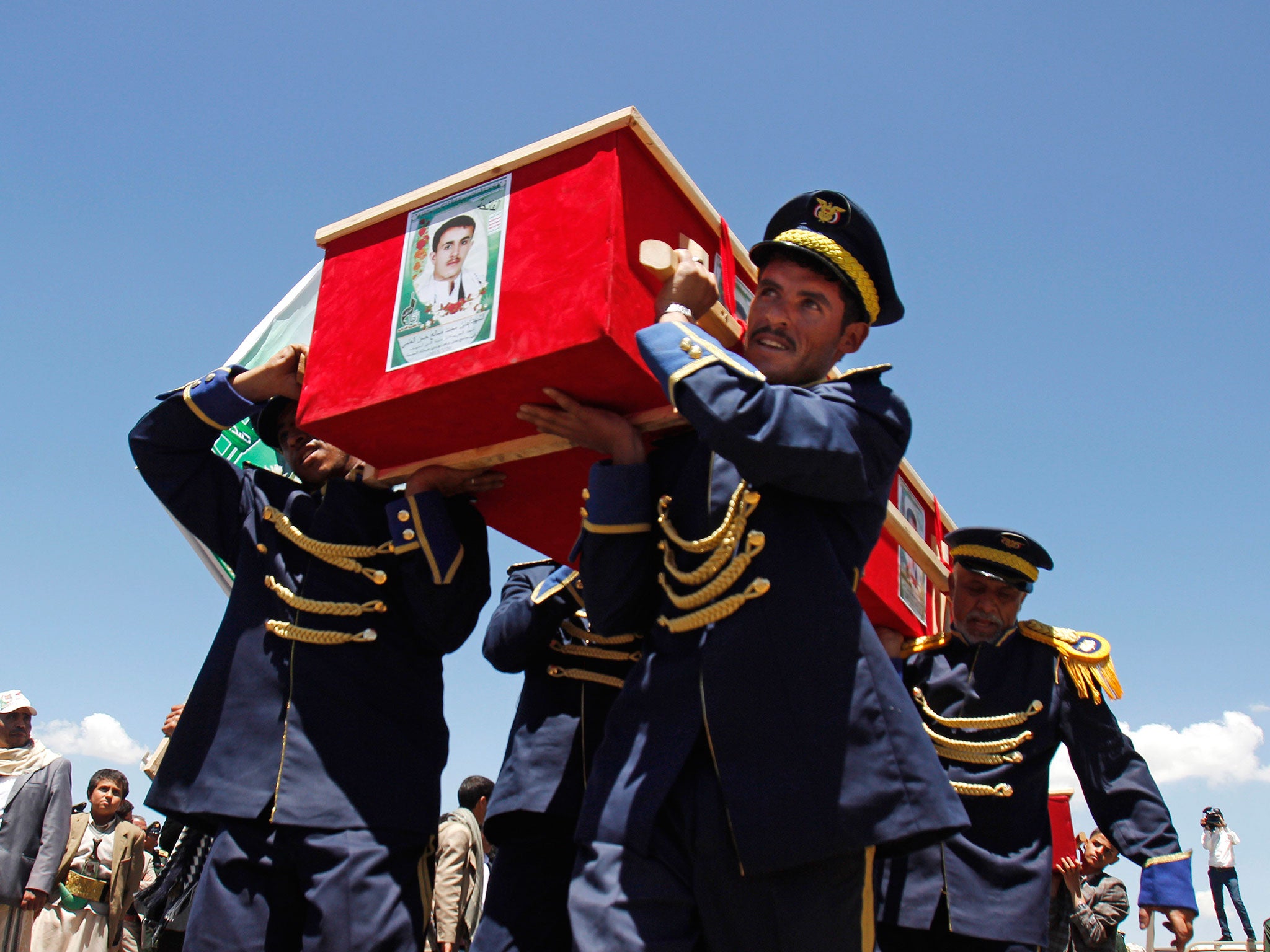 Yemeni honor guards carry the coffins of victims, who were killed last week from triple suicide bombing attacks that hit a pair of mosques, during their funeral procession in Sanaa, Yemen