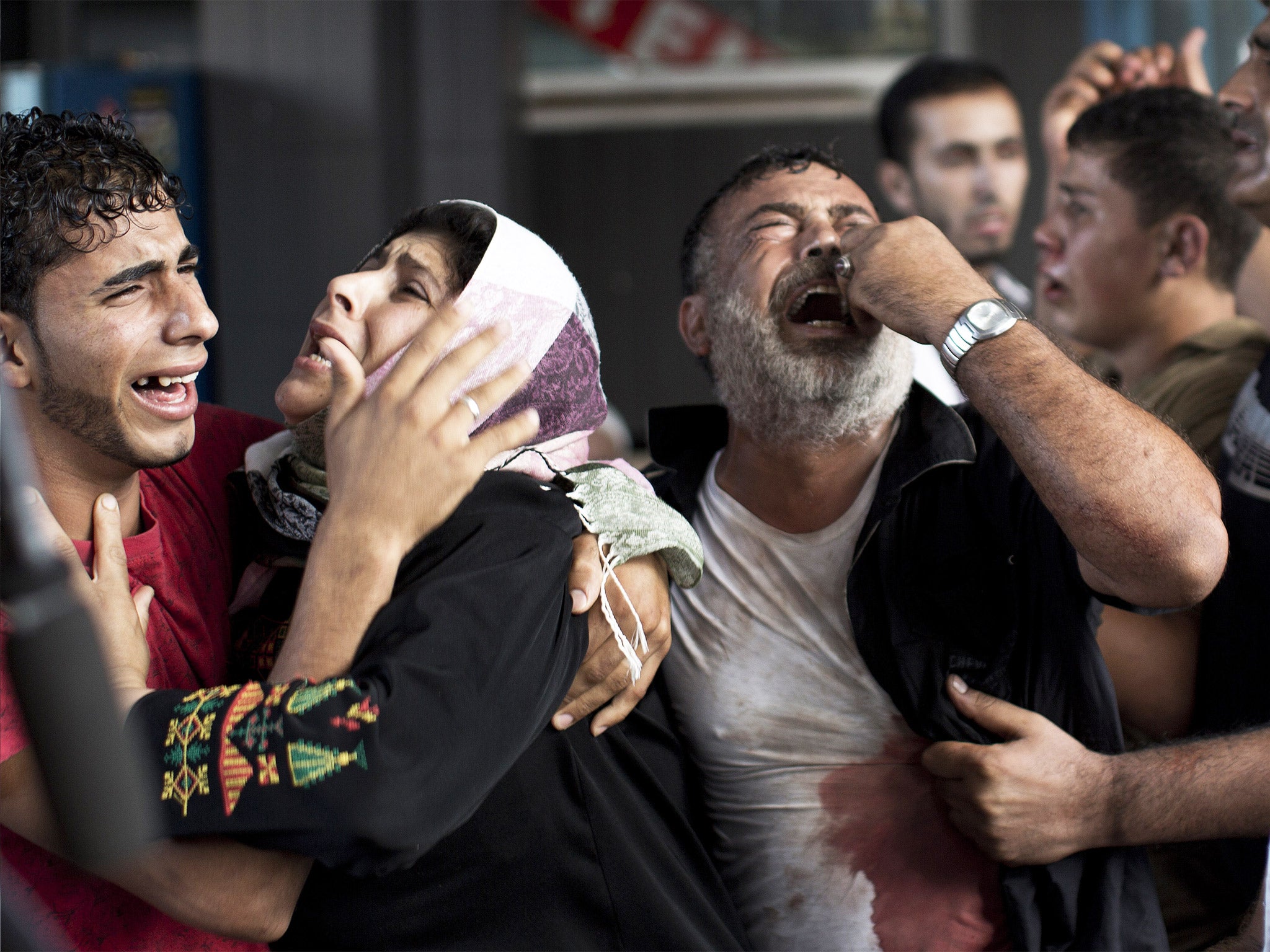 Palestinians weep after a blast killed 11 children in Gaza last July (Getty)