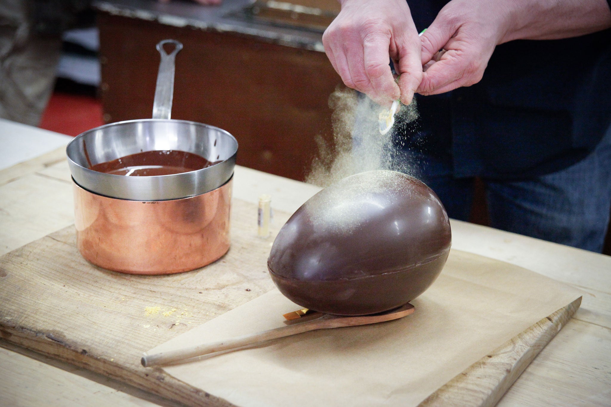 Willie flicks gold dust on to his egg with a toothbrush