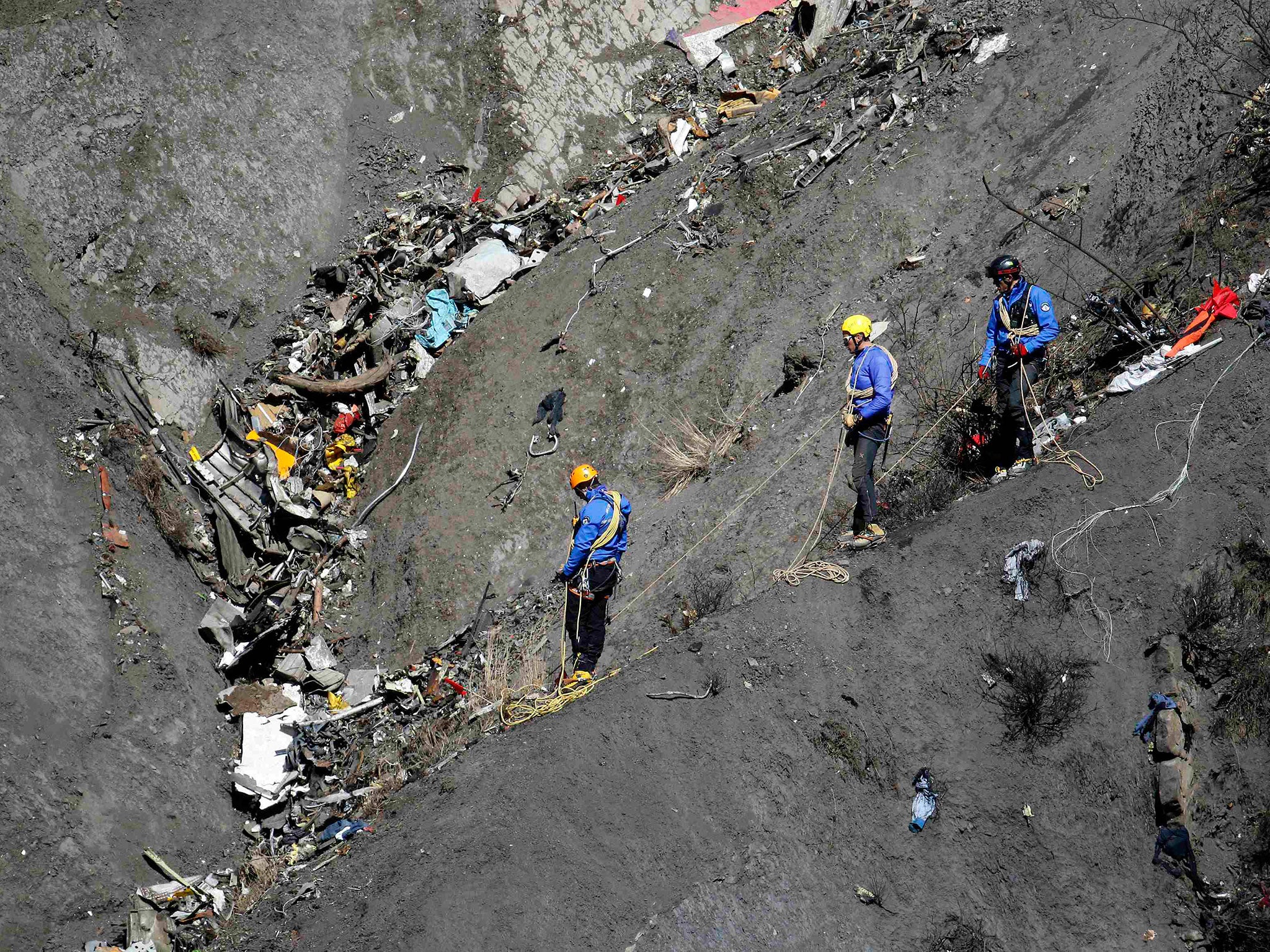 French gendarmes and investigators make their way through the debris of the Airbus A320 at the site of the crash near Seyne-les-Alpes, French Alps