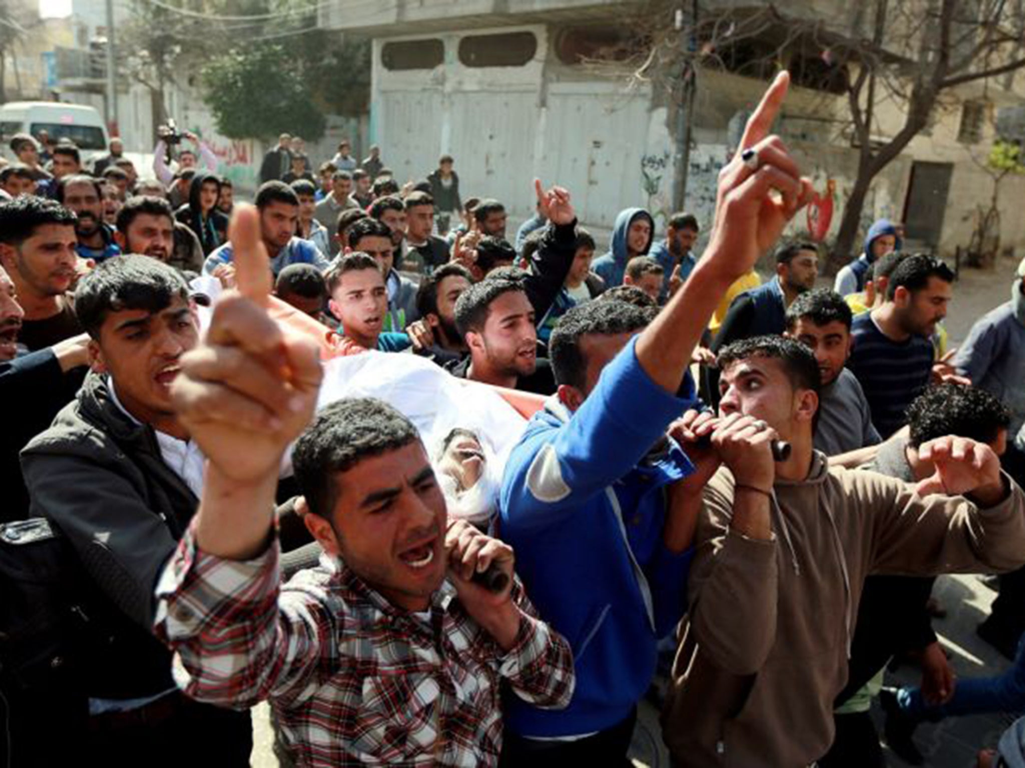 Protesters carry the body of Tawfiq Abu Riyala