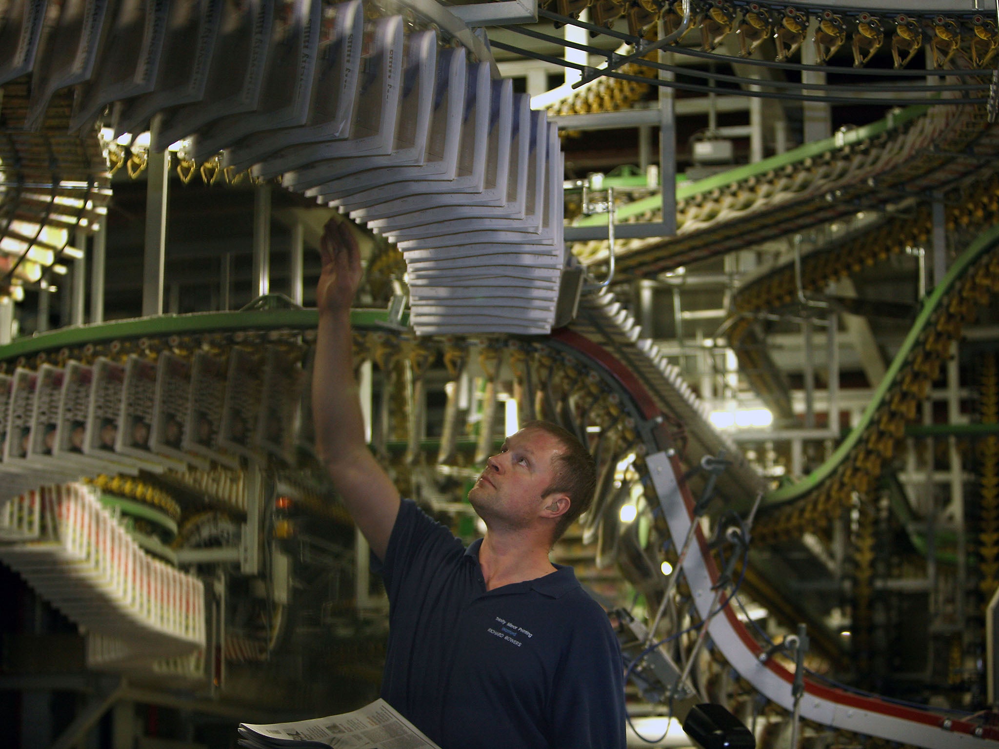 A worker at Trinity Mirror printing warehouse checks the the first ever printed copies of the 'i' off the press ahead of their distribution in Watford, Hertfordshire, 25 October 2010.