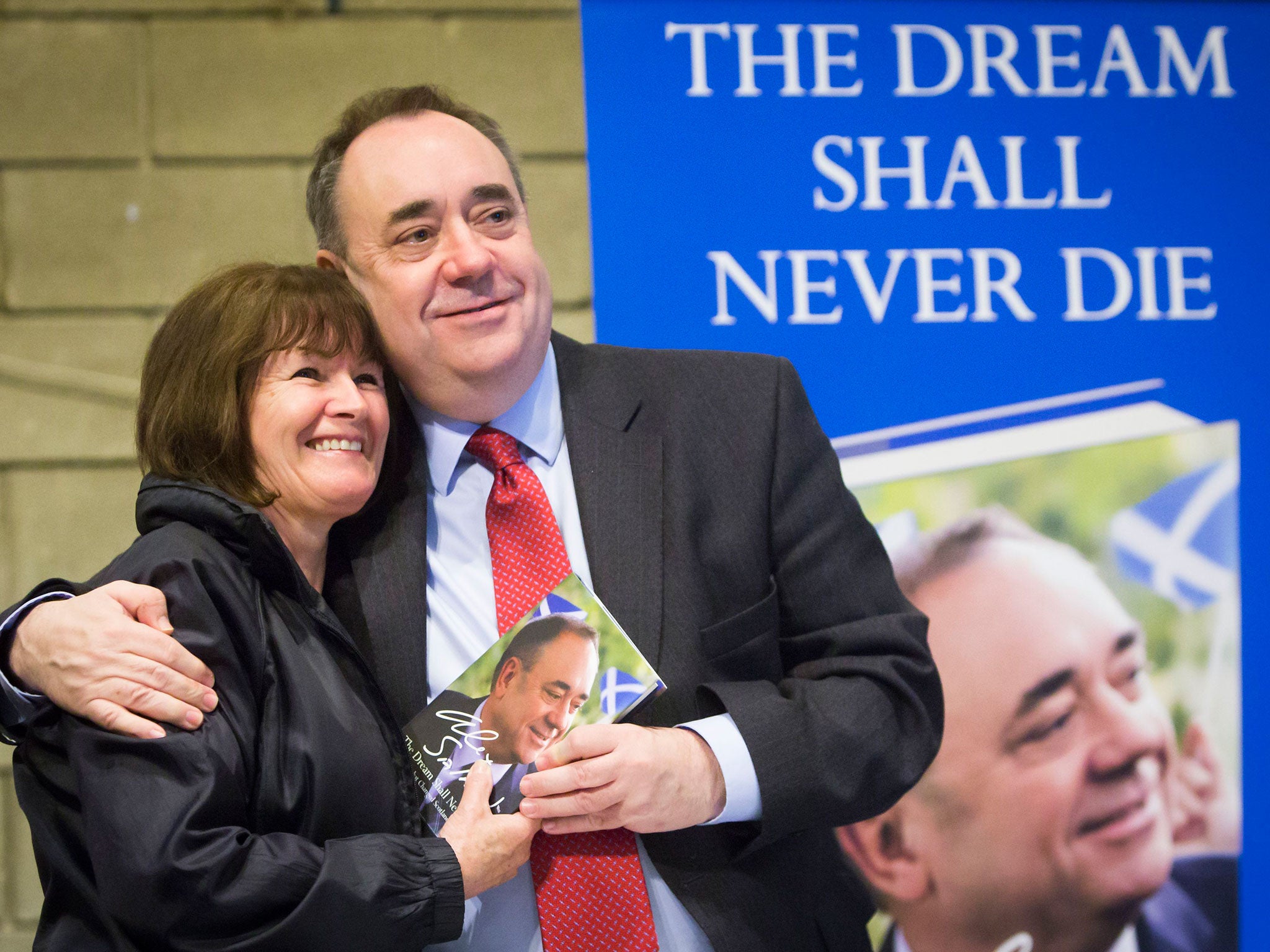 Former leader Alex Salmond has his picture taken as he signs copies of his book The Dream Shall Never Die during the SNP conference