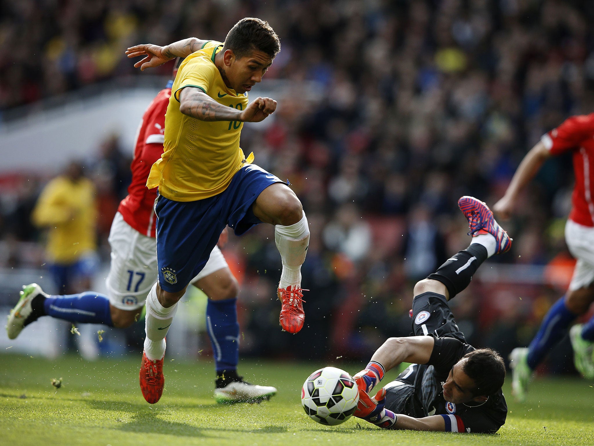 Brazil’s Roberto Firmino rounds Chile goalkeeper Claudio Bravo to score the winner