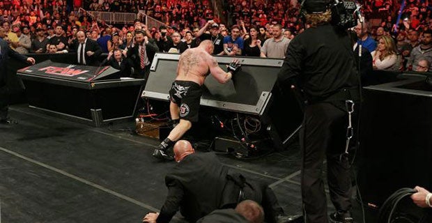 Lesnar flips over the announcers table