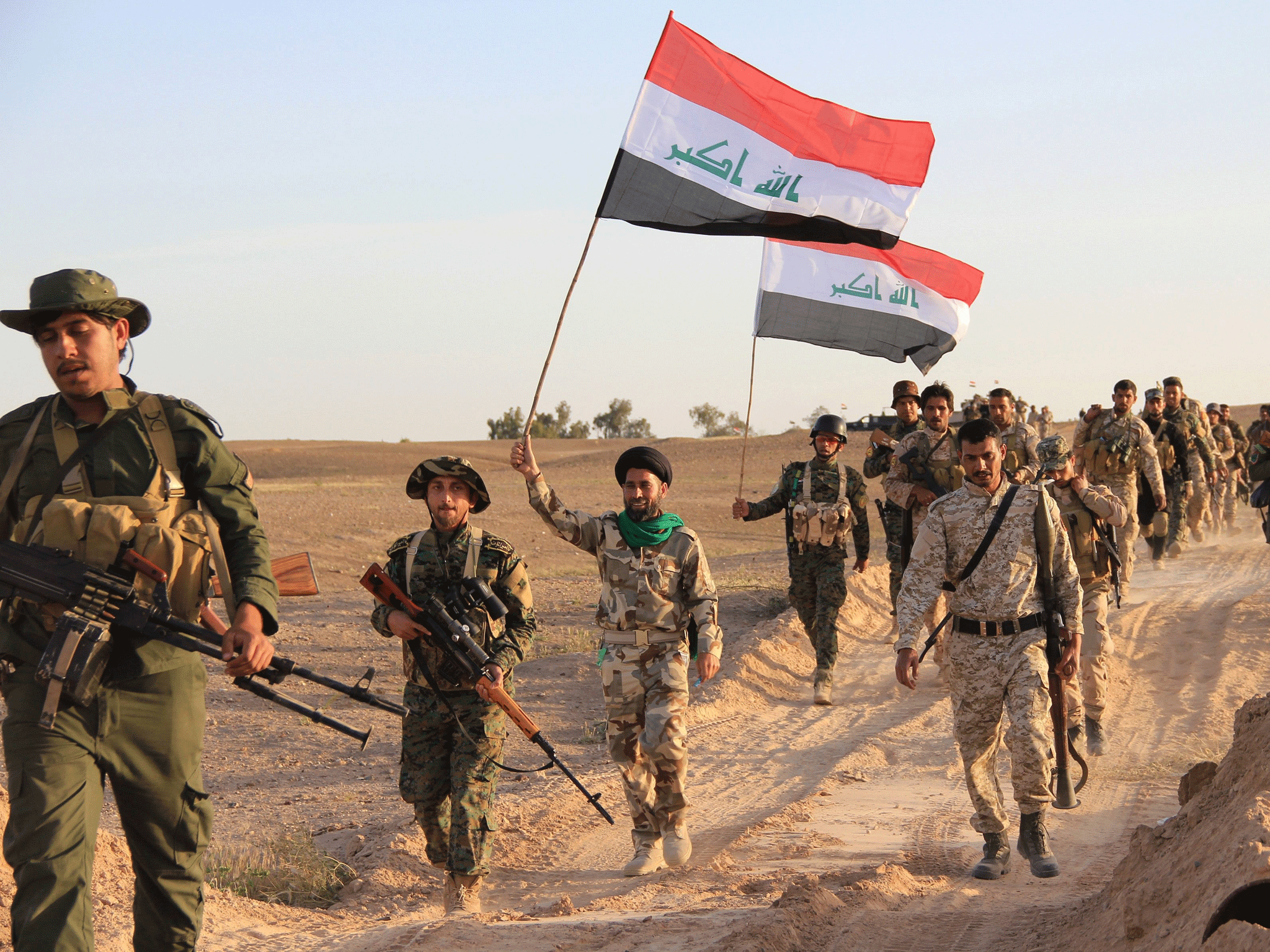 Iraqi soldiers and members of Iraqi Shia militia carry the Iraqi flag in Tikrit