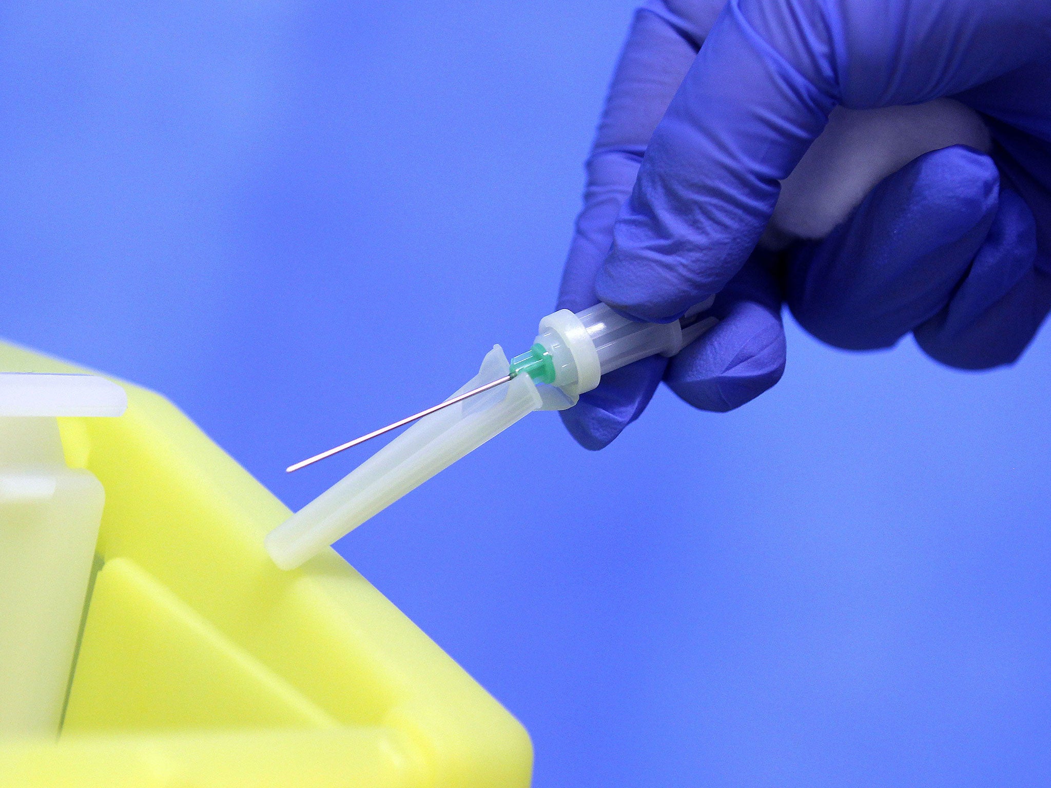 A medical professional holding a needle