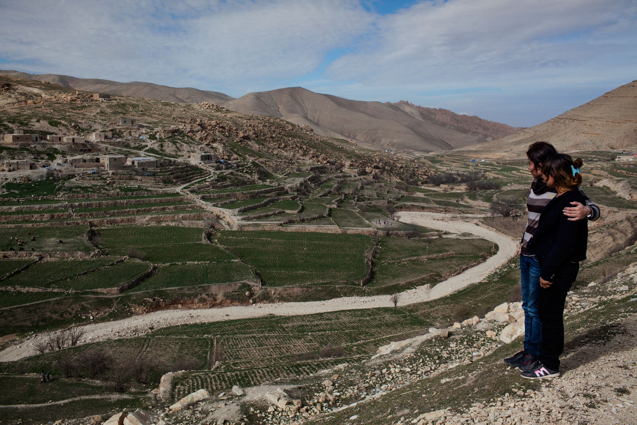 Amel and her friend Perez look out over Sinjar Mountain, February 2015