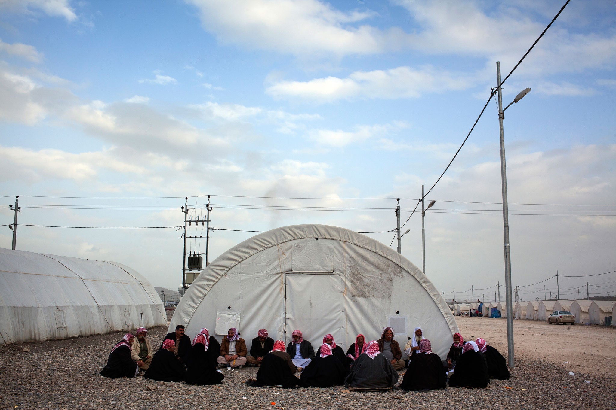 Yazidi men from Sinjar sit and talk in a camp for the displaced near the northern city of Zakho