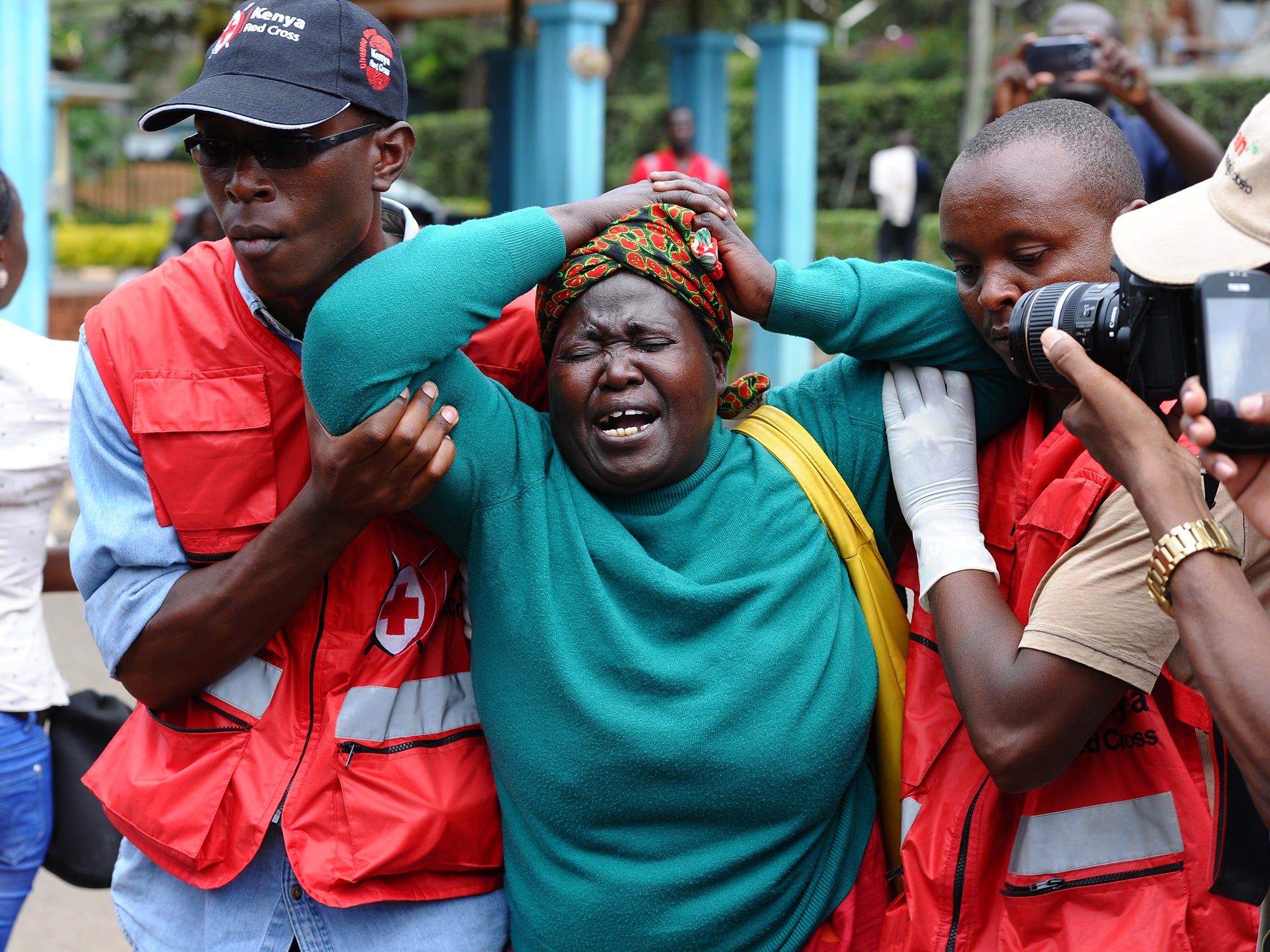 A woman is helped by Red Cross staff after viewing a relative’s body at Garissa University