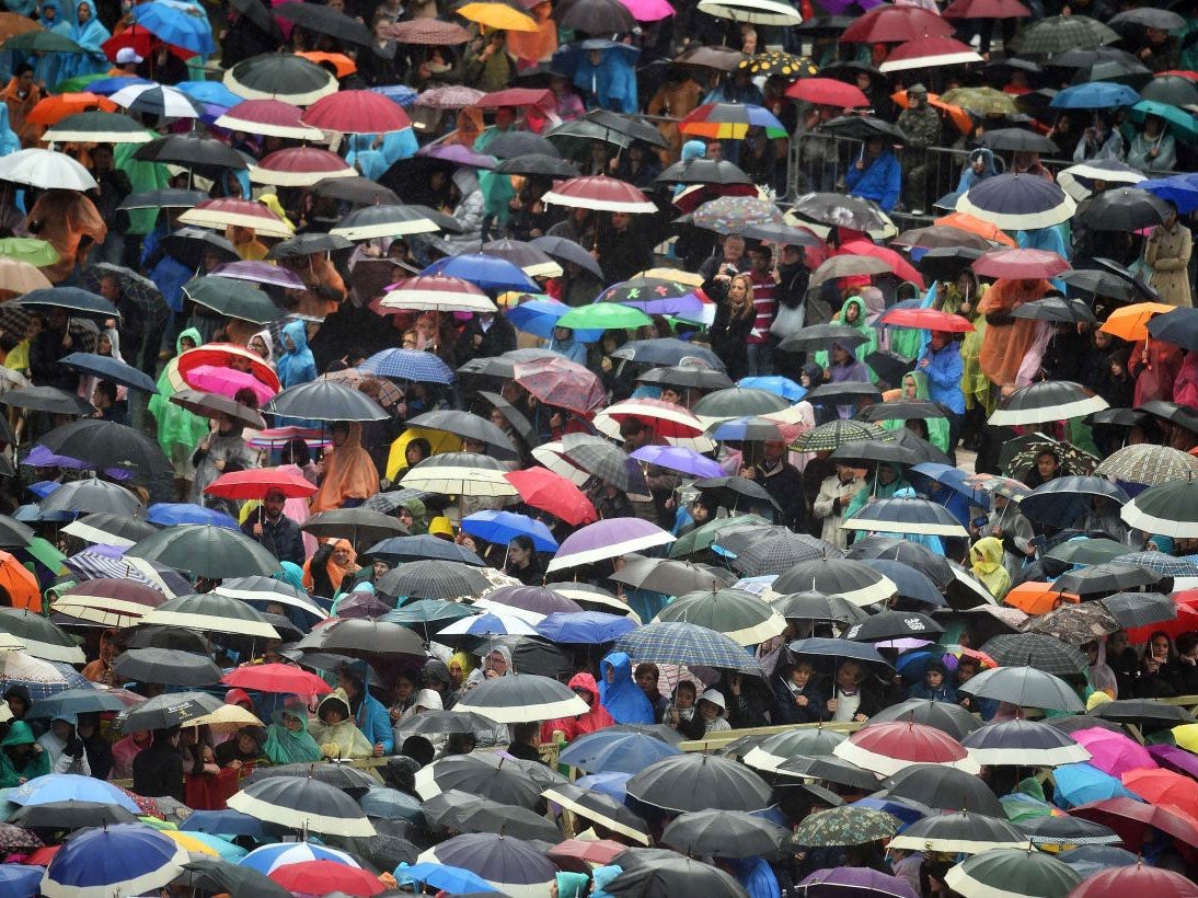 Worshippers gather in the rain to see the address