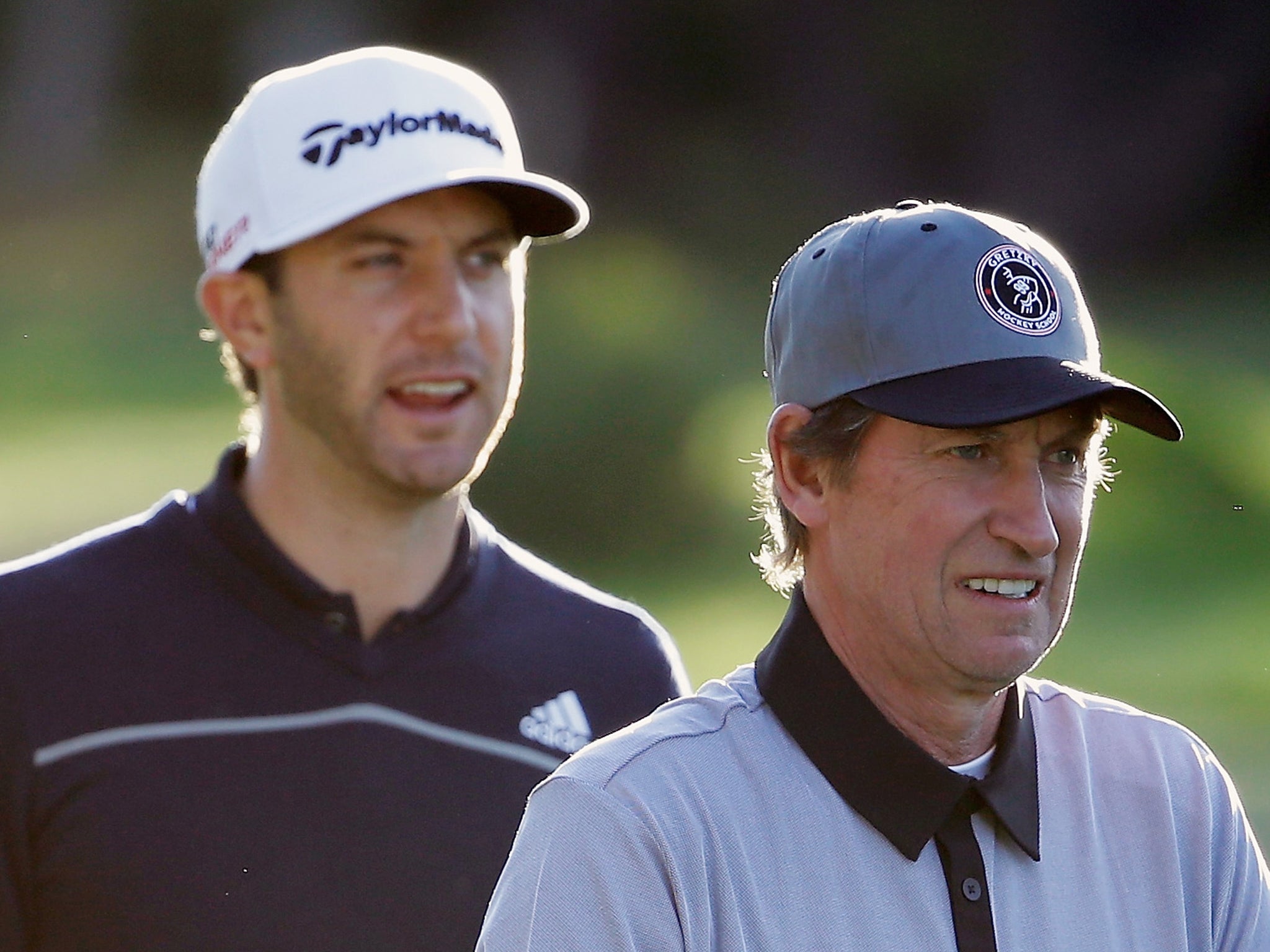 Dustin Johnson (L) waits alongside hockey legend Wayne Gretzky