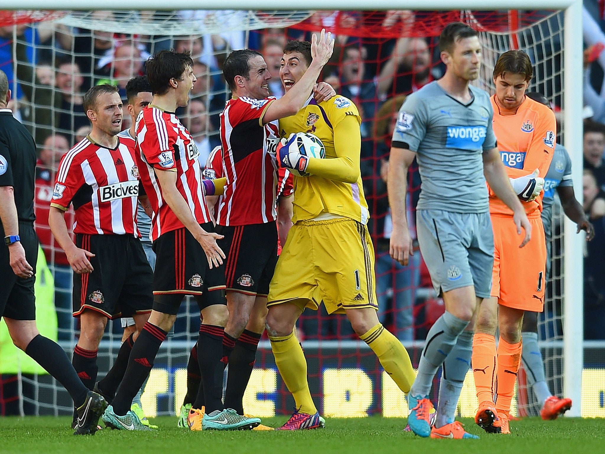 The Sunderland players celebrate after the final whistle as Newcastle’s Mike Williamson trudges away