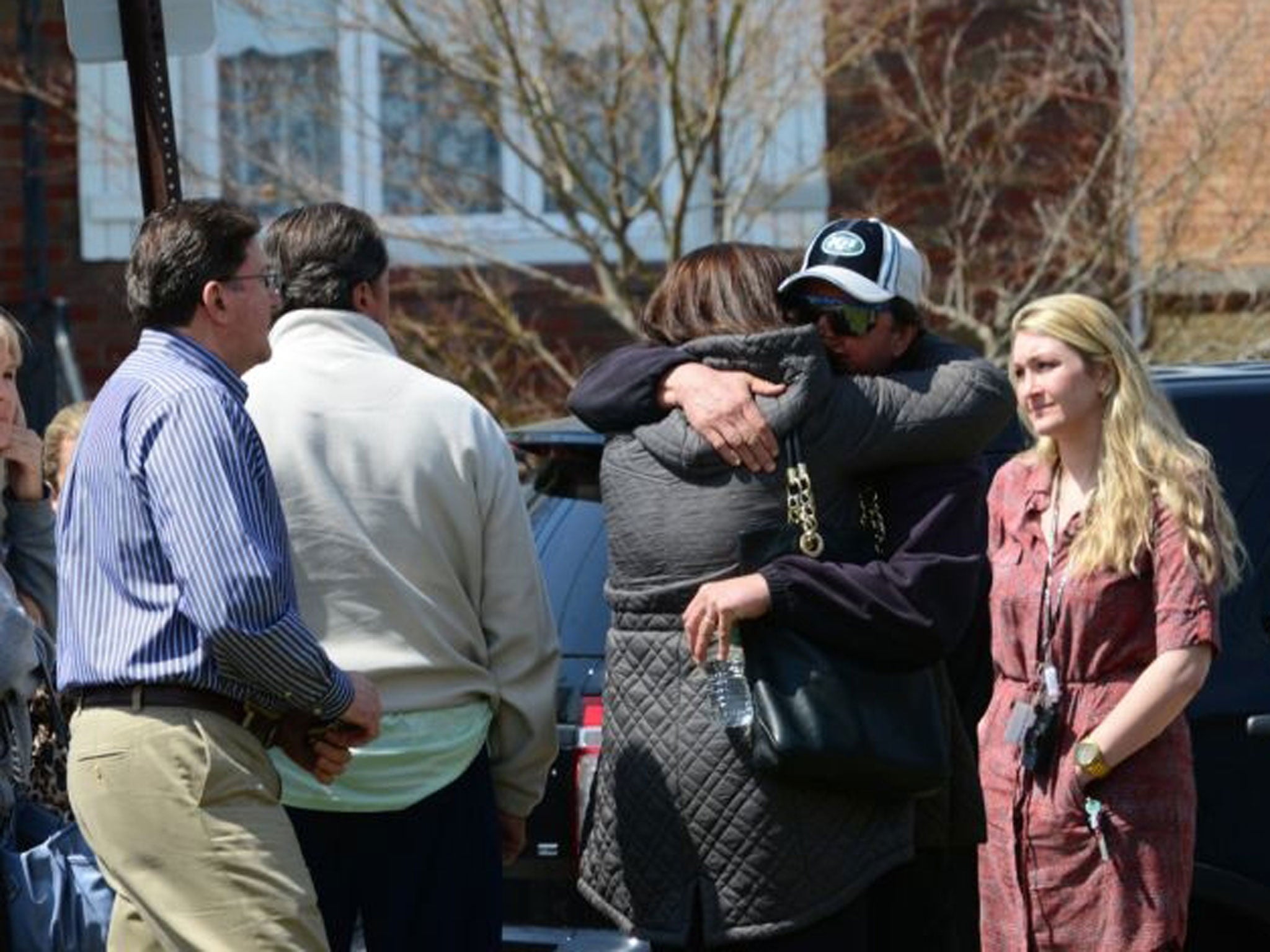 People gather across the street from the home where the bodies the couple were found. (Image: AP/Tariq Zehawi)