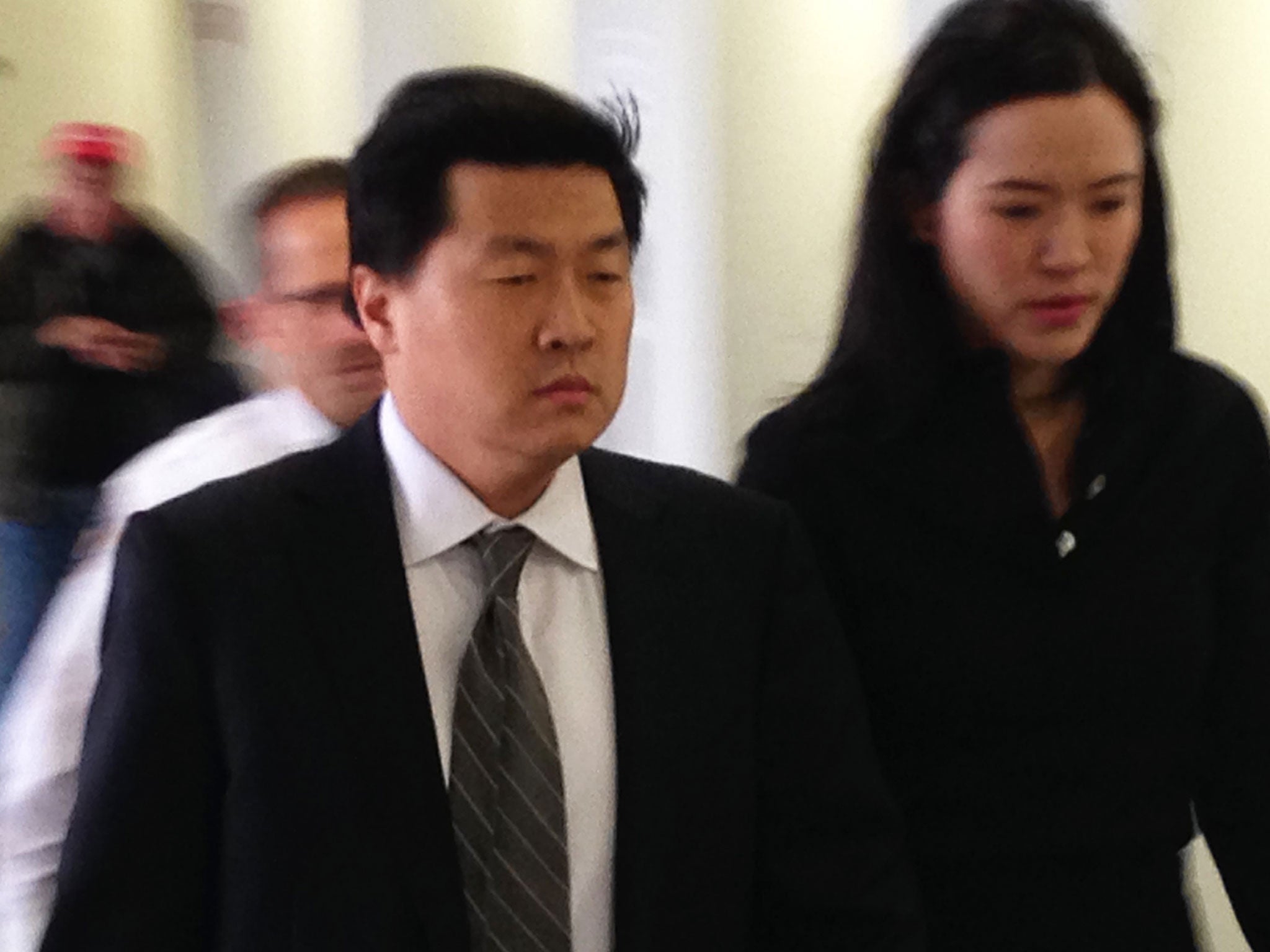 Former New York City investment banker Jason Lee walks with his wife Alicia into Suffolk County Court on Wednesday 8 April, 2015