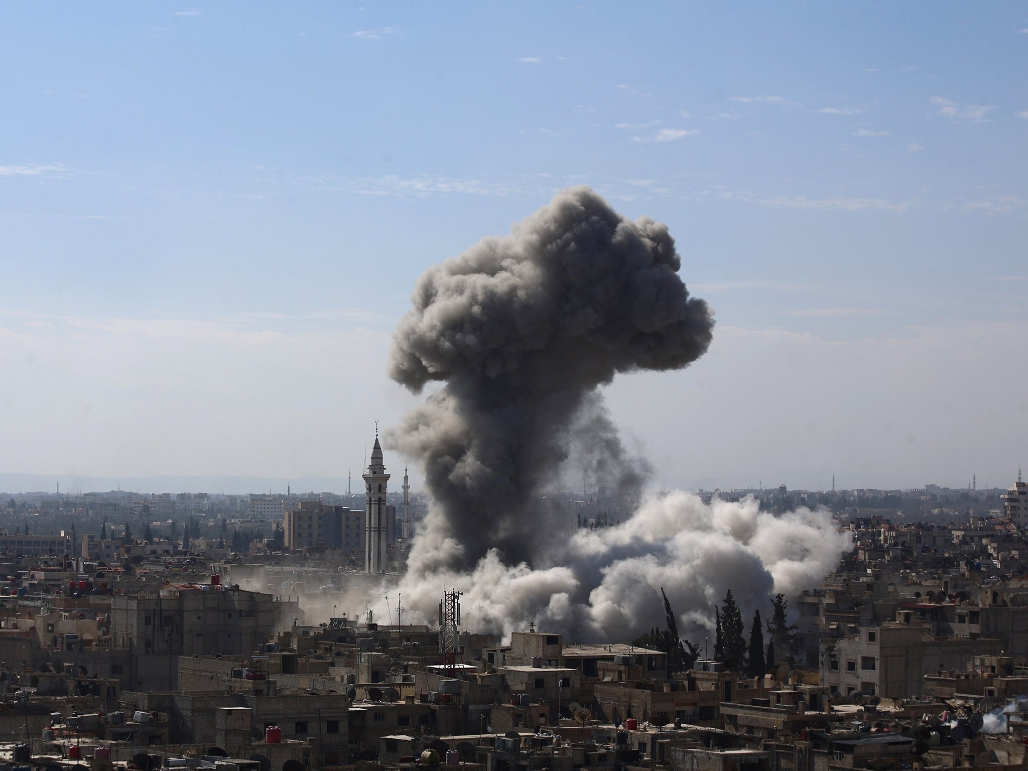 A cloud of smoke rises following an air strike by Syrian government forces in the rebel-held area of Douma, north east of the capital Damascus (Getty)