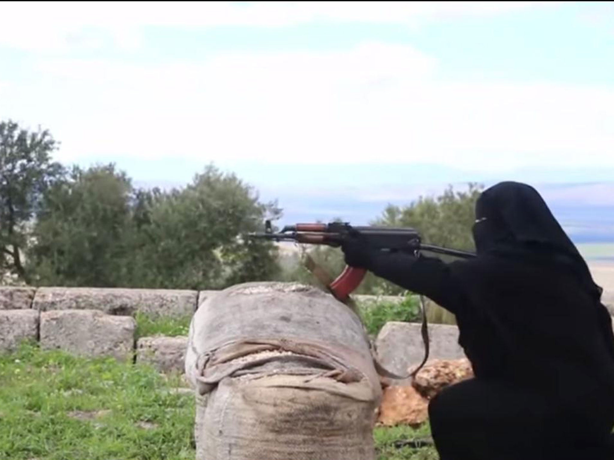 A female Isis militant practices shooting with a gun