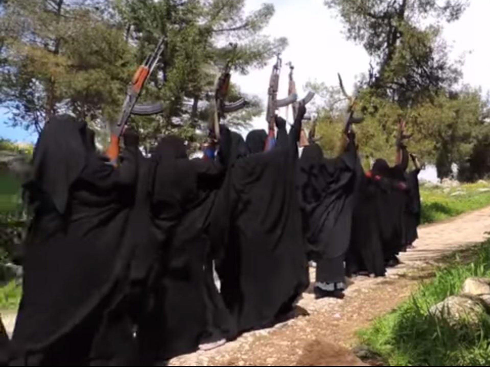 Women walk through brandishing guns and shouting