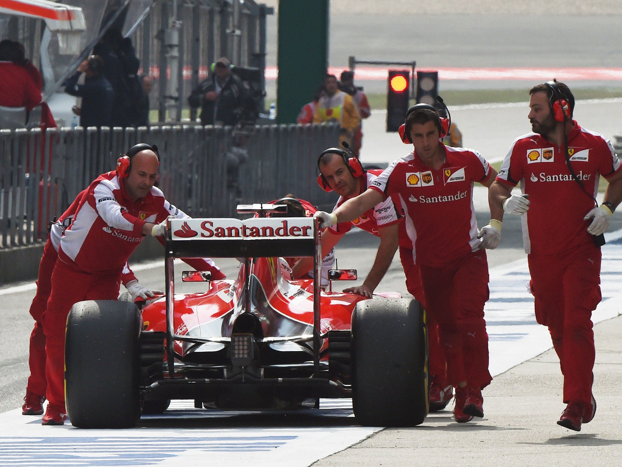 Vettel is wheeled back into the Ferrari garage