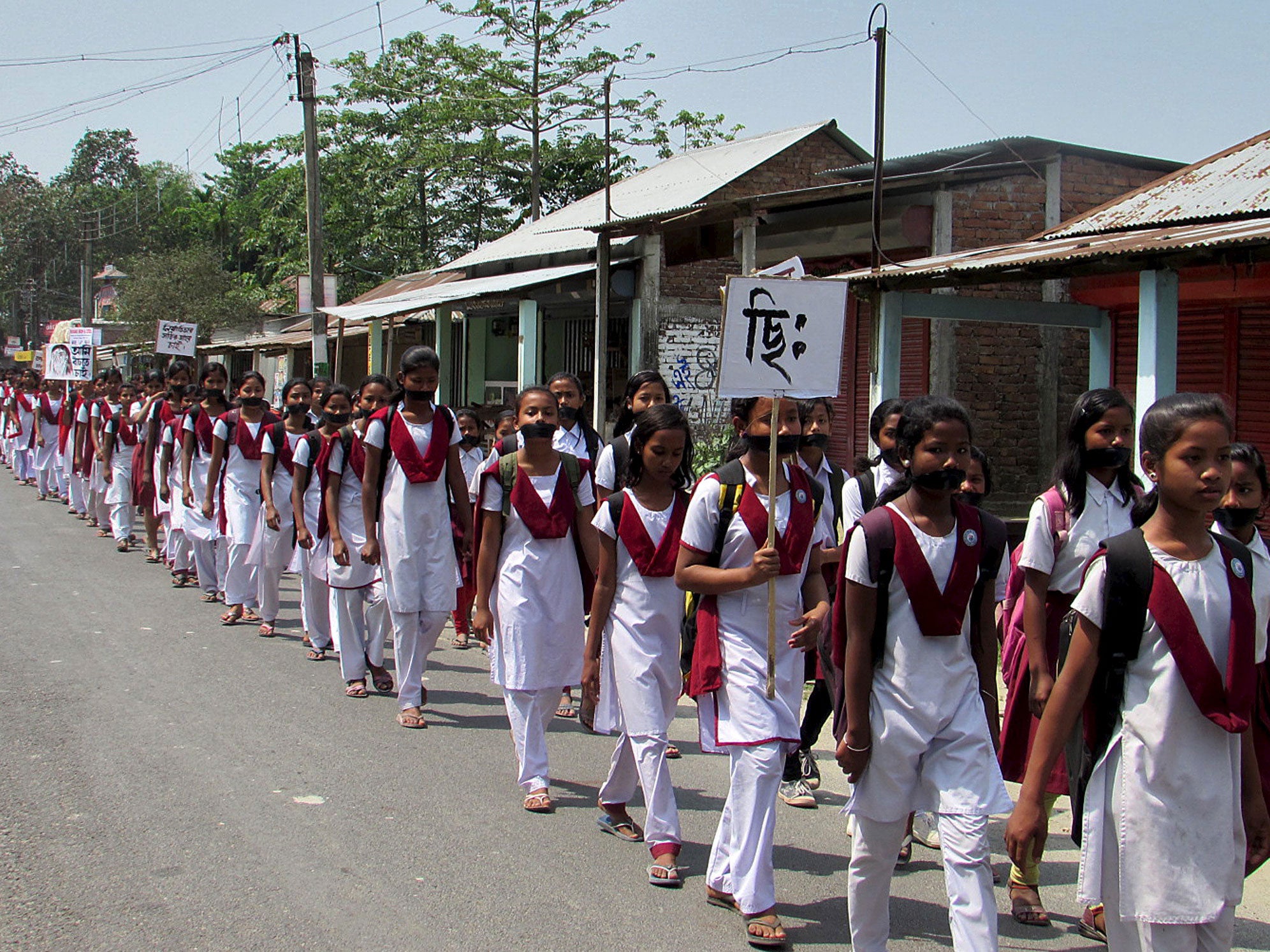 School girls wear black bands on their faces during a protest rally against the rape case of a 16-year-old girl at Dhupguri town in the eastern Indian state of West Bengal