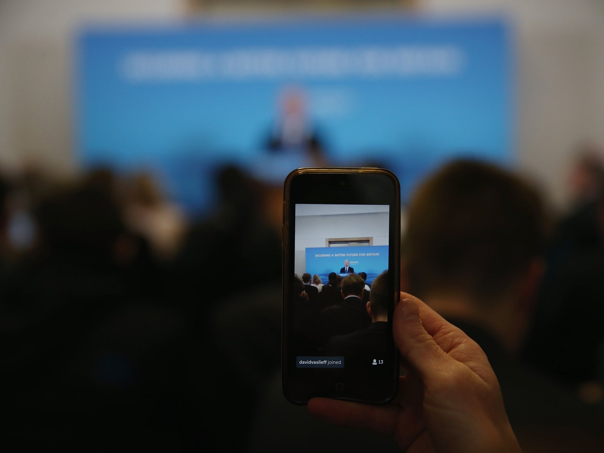 A reporter live streams via a twitter as Defence Secretary Michael Fallon gives a press conference on April 9, 2015 in London