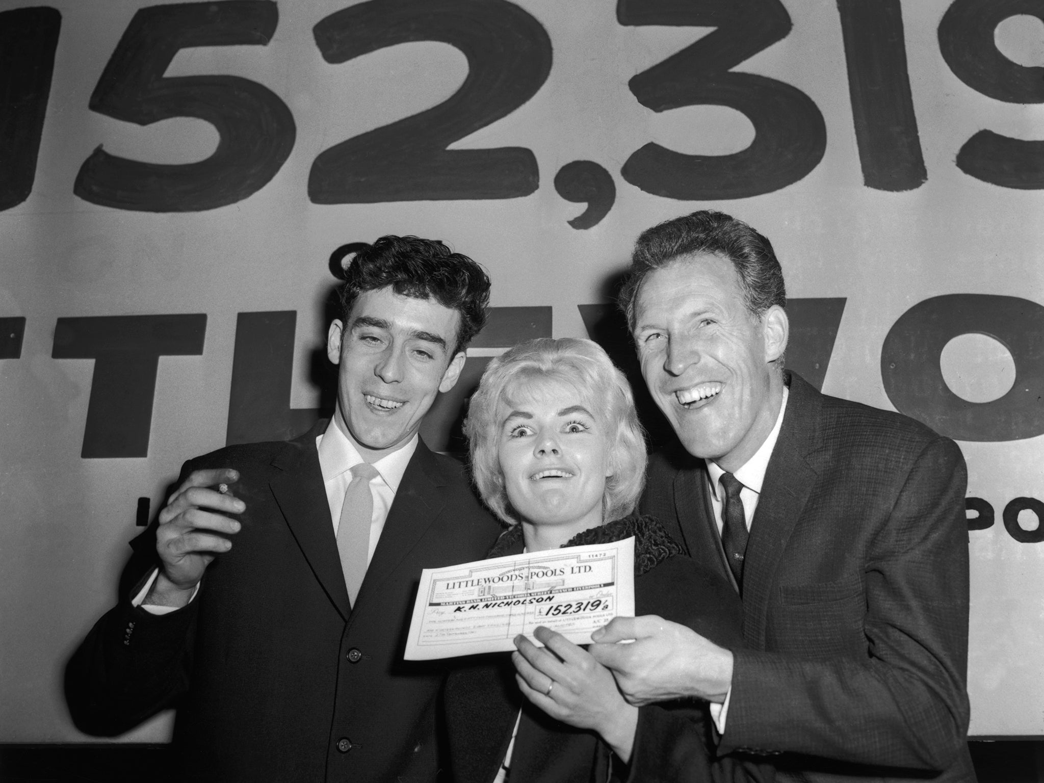 Bruce Forsyth, right, presents the winning pools cheque to Nicholson and her
husband Keith in 1961