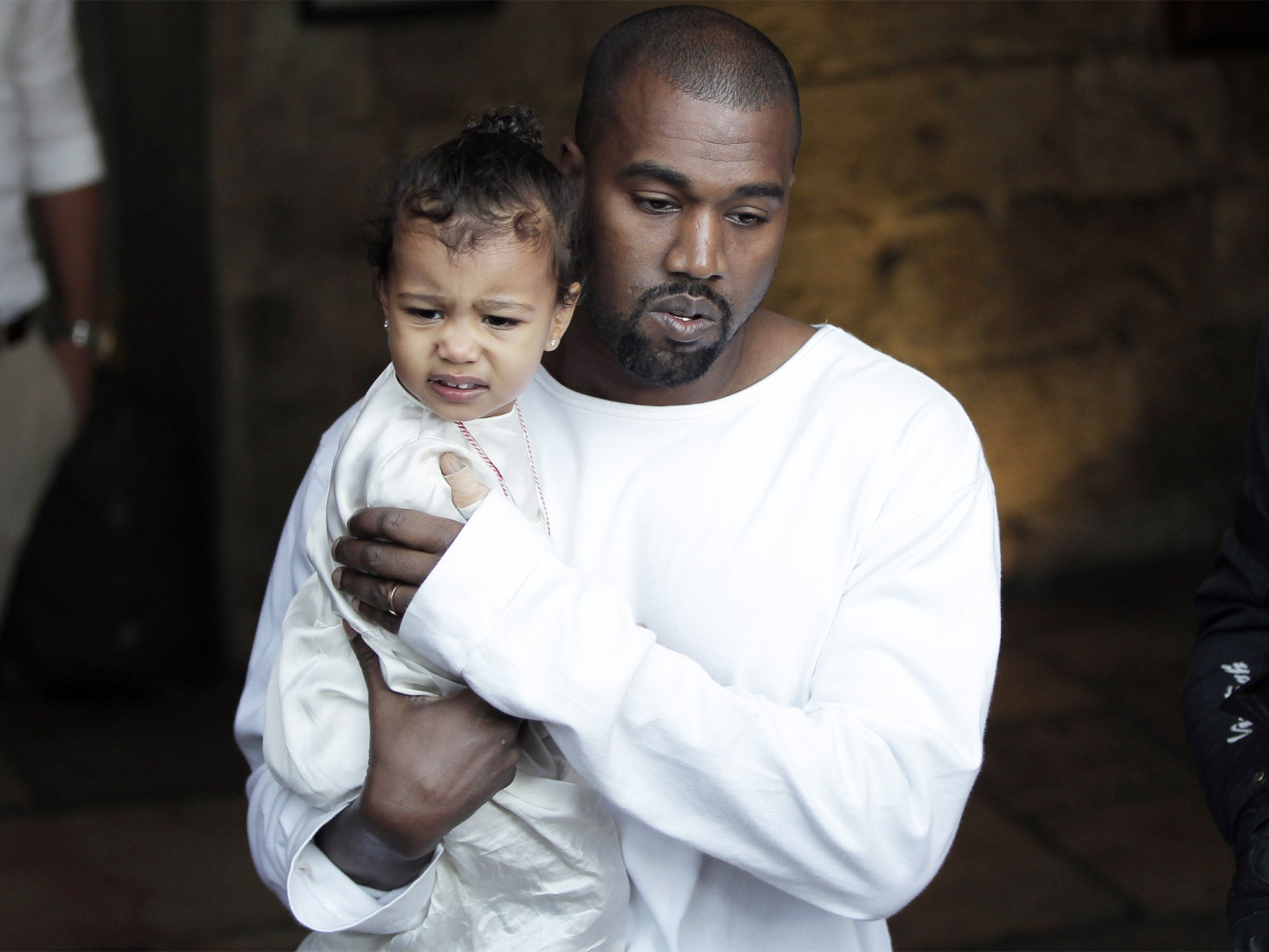 Rapper Kanye West carries daughter North following the baptism ceremony in Jerusalem