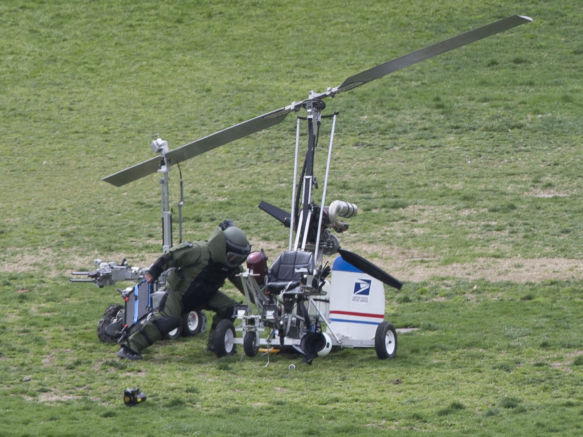 A bomb squad officer inspects the gyrocopter on the Capitol lawn