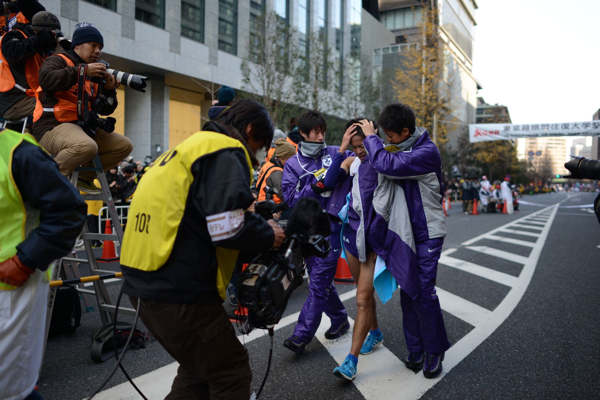 The final leg runner for Komazawa University is inconsolable as his team finishes second in the Hakone ekiden