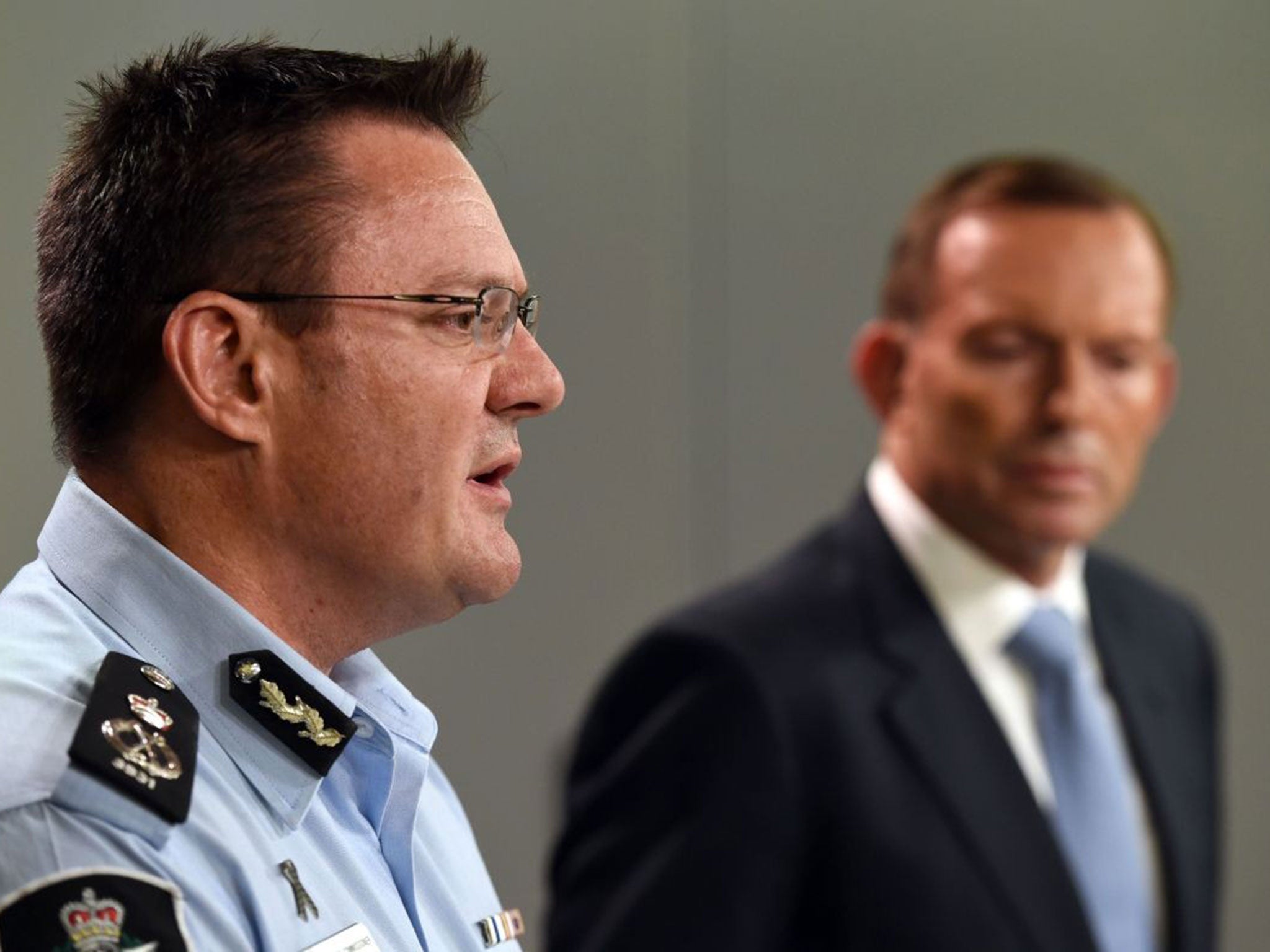 Australian Federal Police deputy commissioner Michael Phelan (L) speaks to the media as Australia's Prime Minister Tony Abbott (R) listens in Sydney on April 18