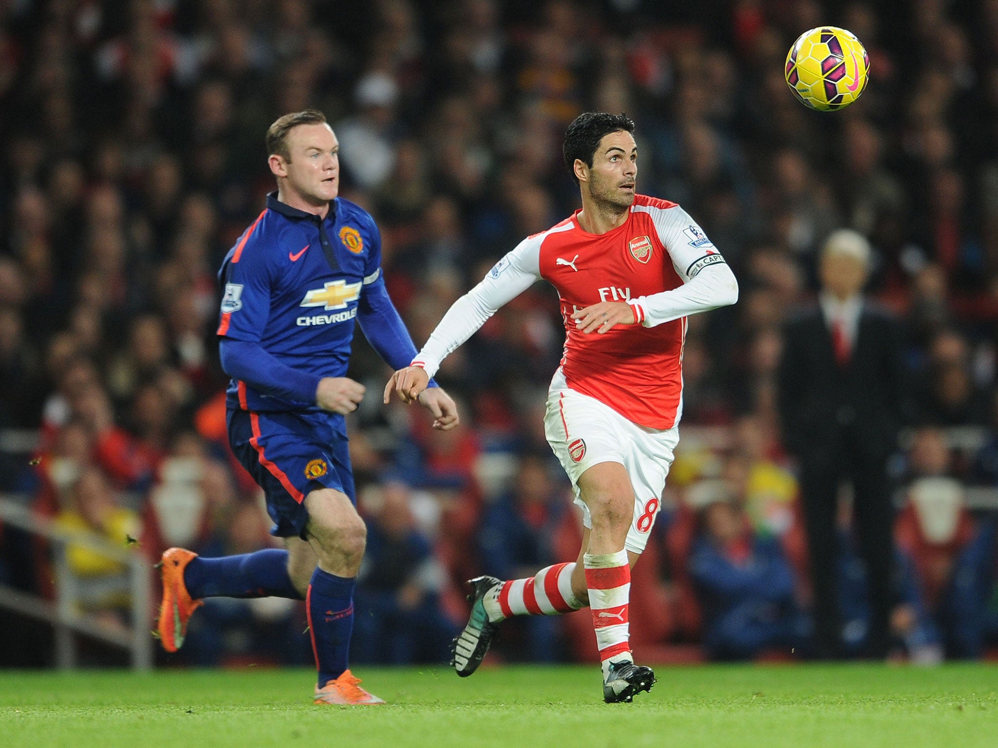 Mikel Arteta holds off Wayne Rooney earlier in the season