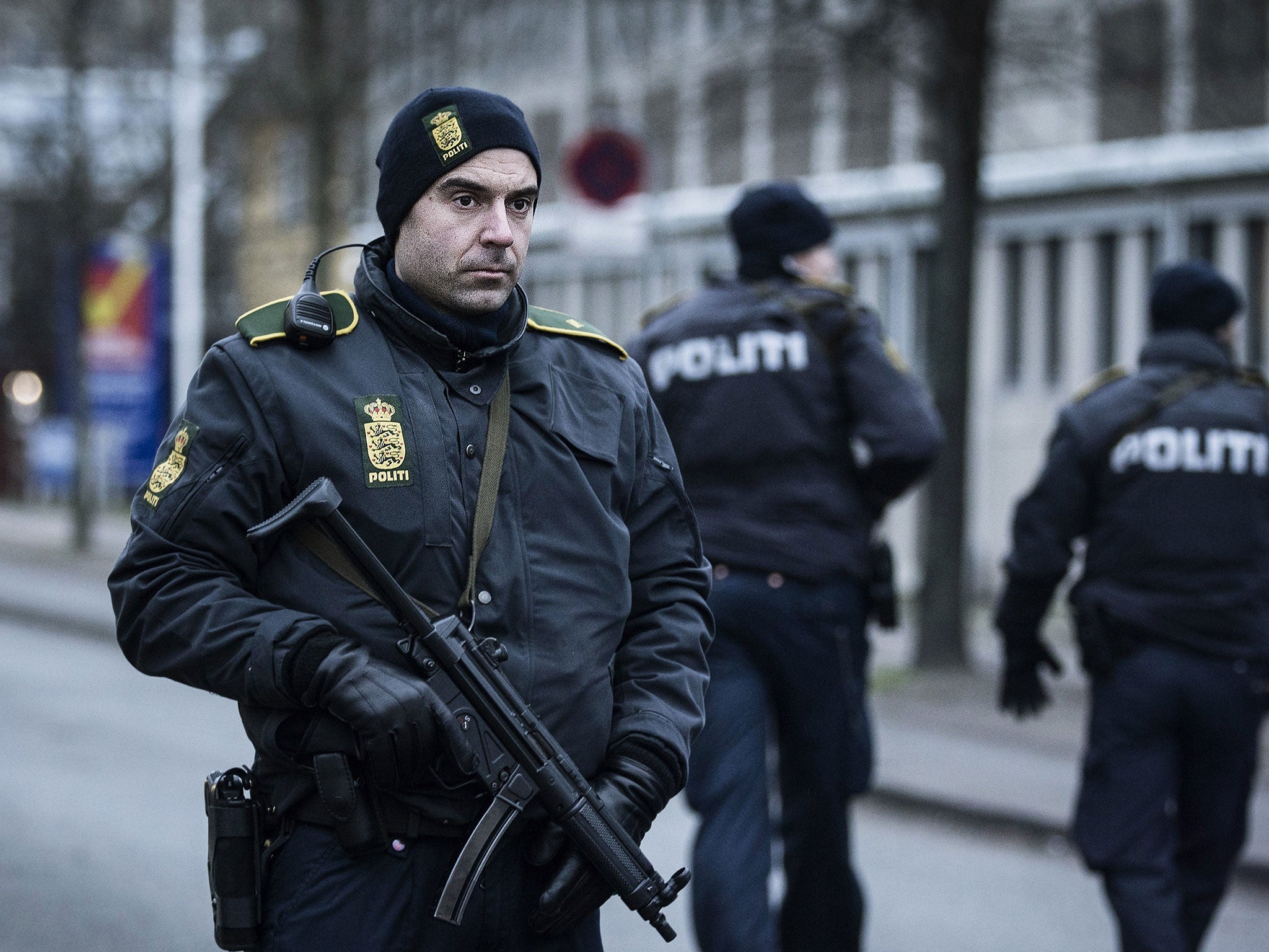 A police officer guards the street around the Noerrebro train station in Copenhagen on February 15, 2015 after a man has been shot in a police action following two fatal attacks in the Danish capital