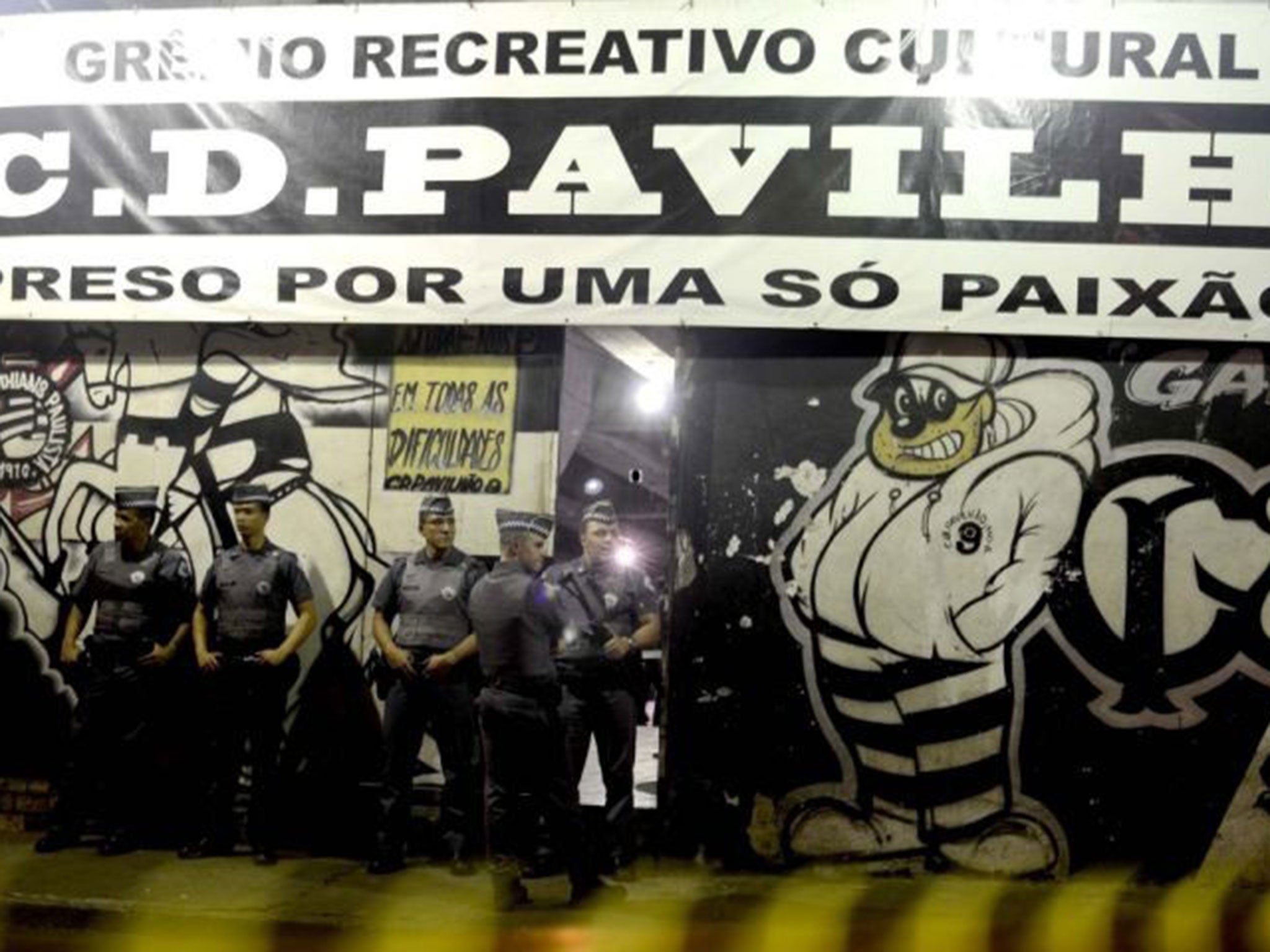 Police officers standing guard outside the headquarters of a fan group for the Corinthians football club, Pavilhao Nove, in Sao Paulo