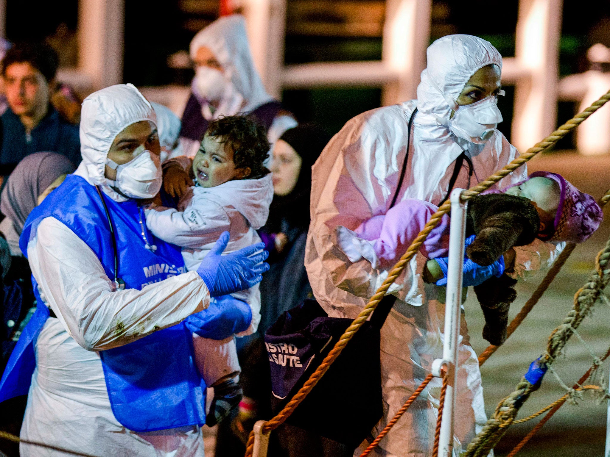 Rescuers help children to disembark in the Sicilian harbor of Pozzallo