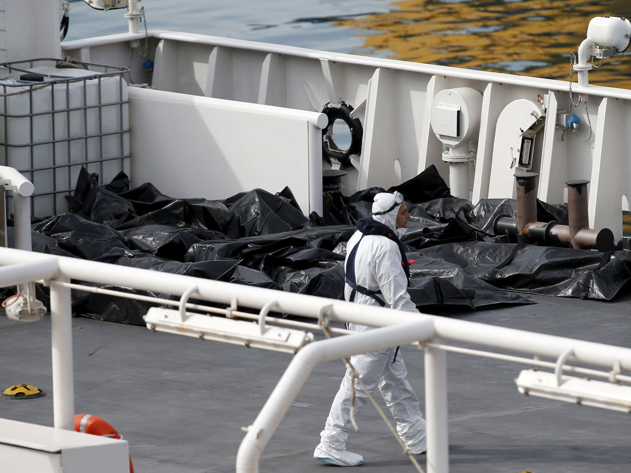 Bodies of dead immigrants lie on the deck of the Italian coastguard ship