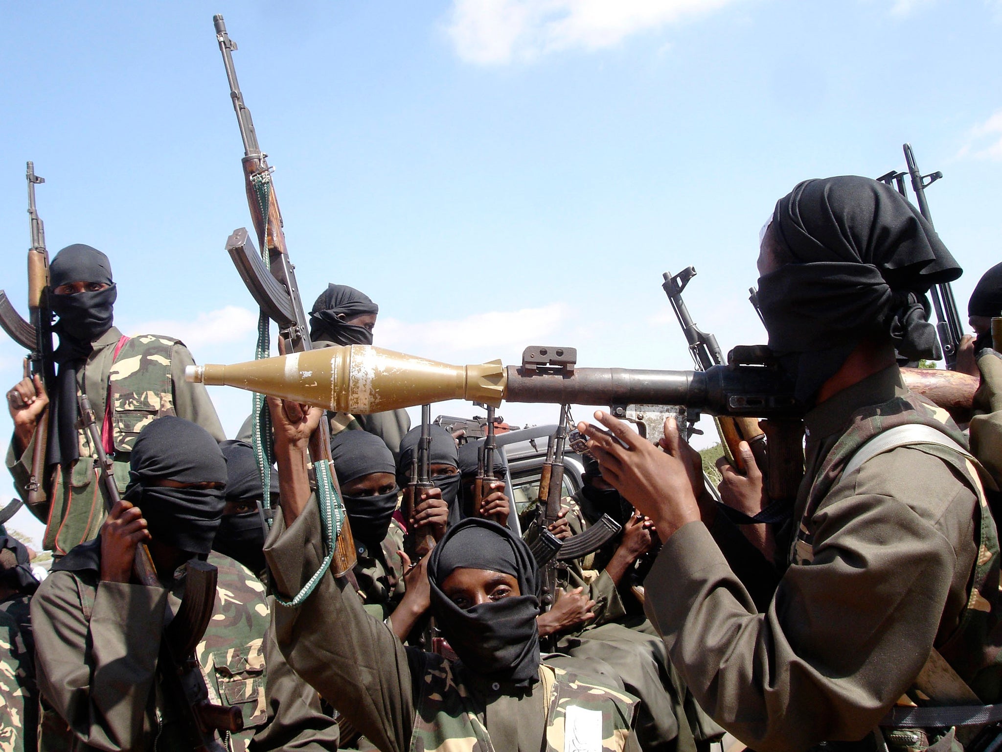 Al-Shabaab militants bearing rifles and a rocket launcher