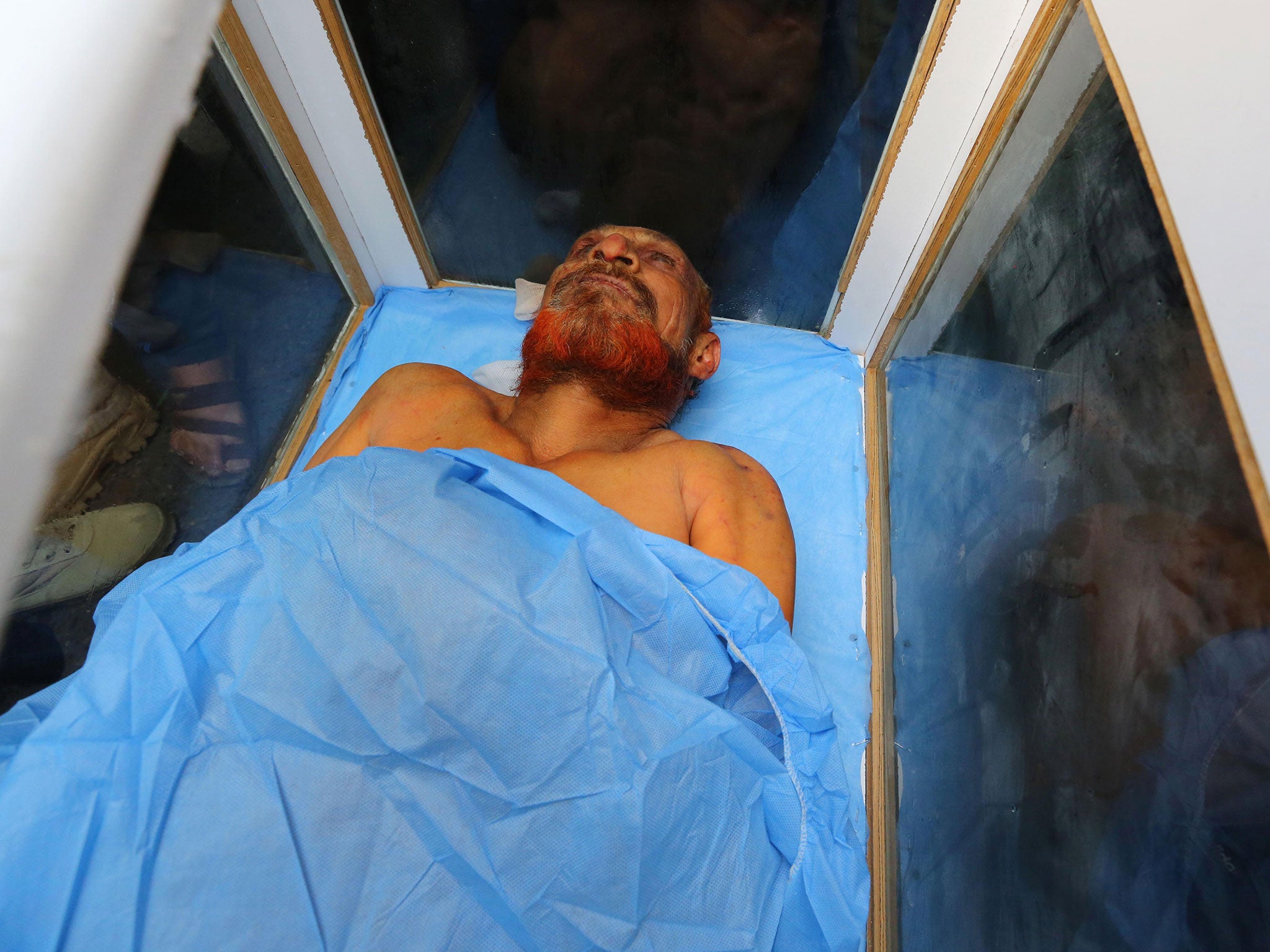 Civilians and members of the Iraqi Hezbollah Brigades prepare to deliver what they claim is the body of former Saddam Hussein deputy Izzat Ibrahim al-Douri