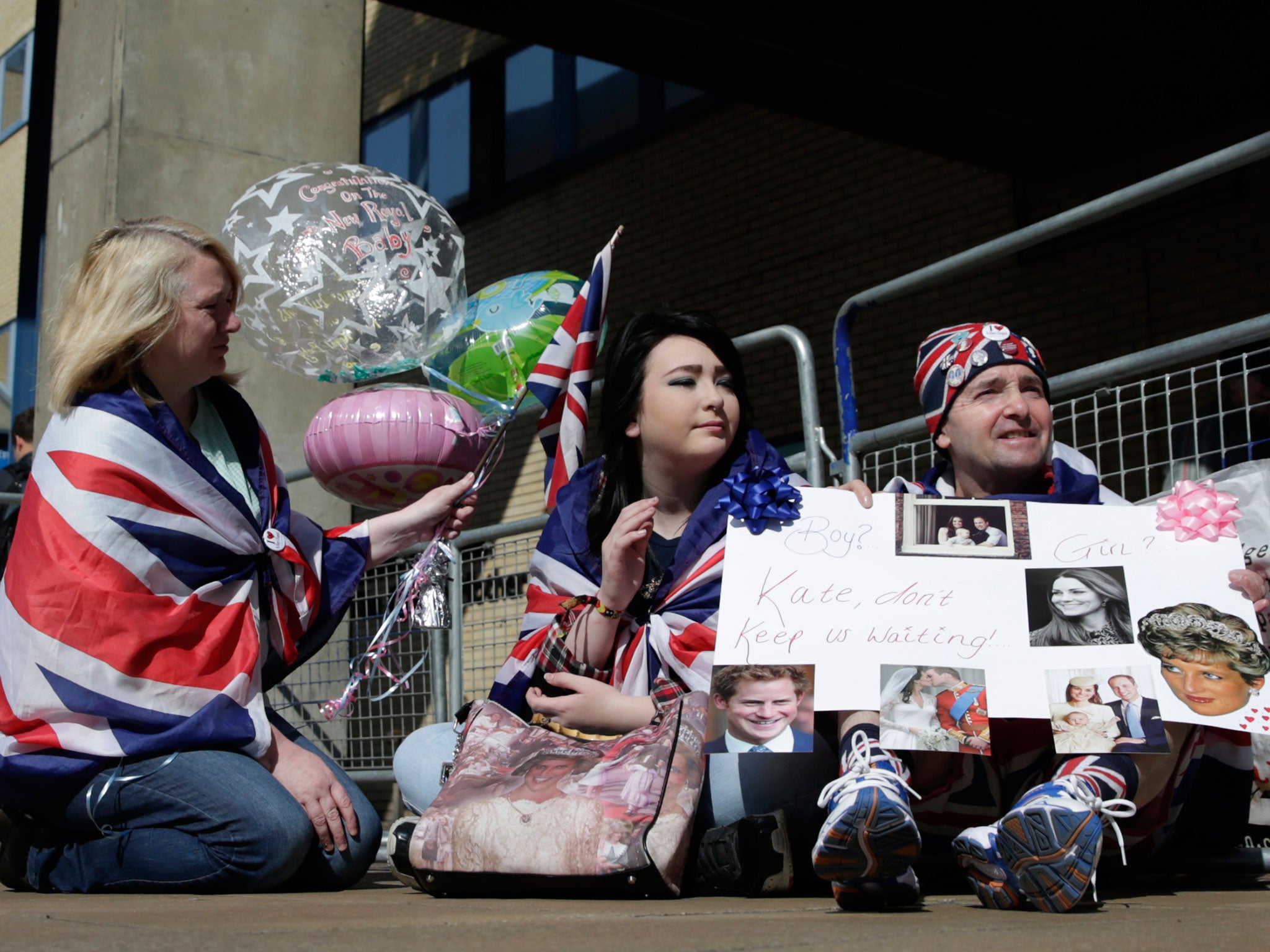 Royal fans Maria Scott, left Amy Thompson and John Loughrey wait outside the Lindo Wing at St Mary's Hospital in London