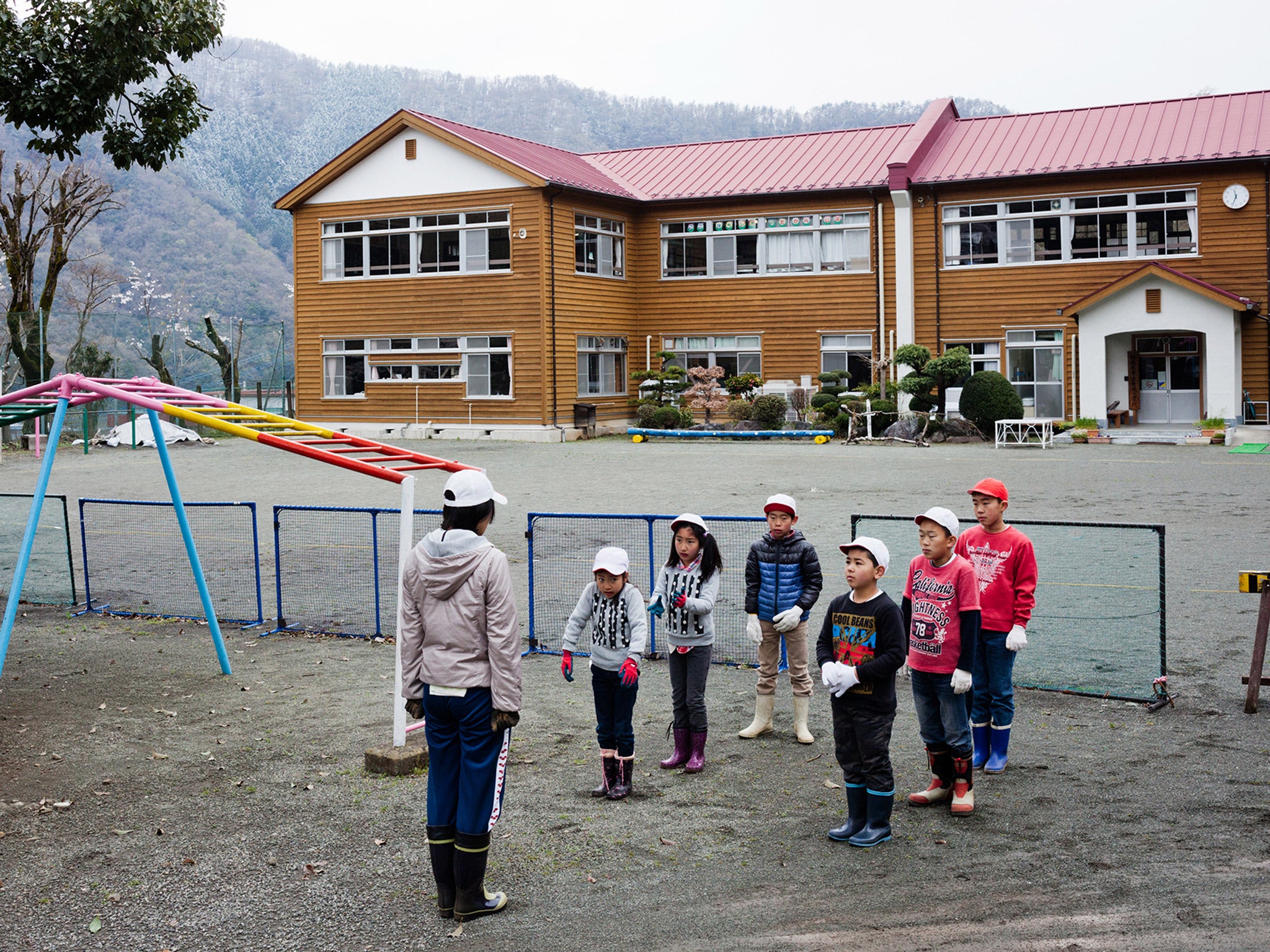 Aone elementary students line up in front of a teacher before leaving school to plant seeds in a potato field nearby