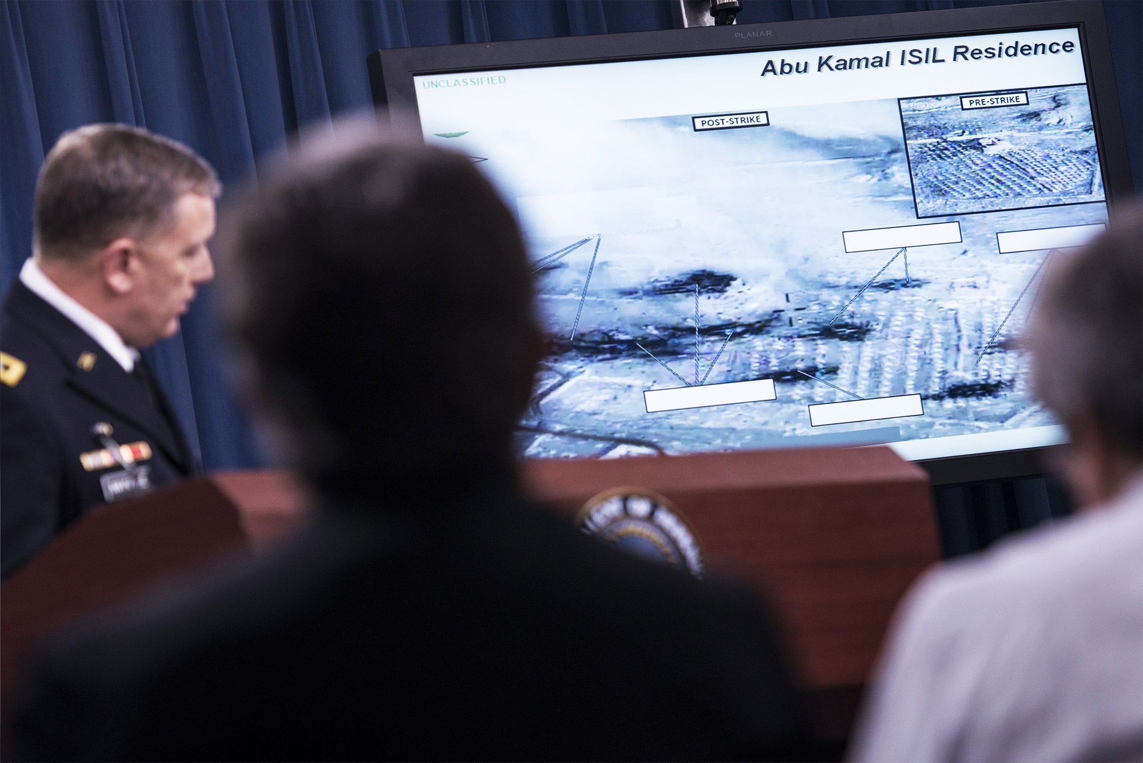 The US Joint Chiefs of Staff director of operations shows photos of the impact of air strikes on Syria