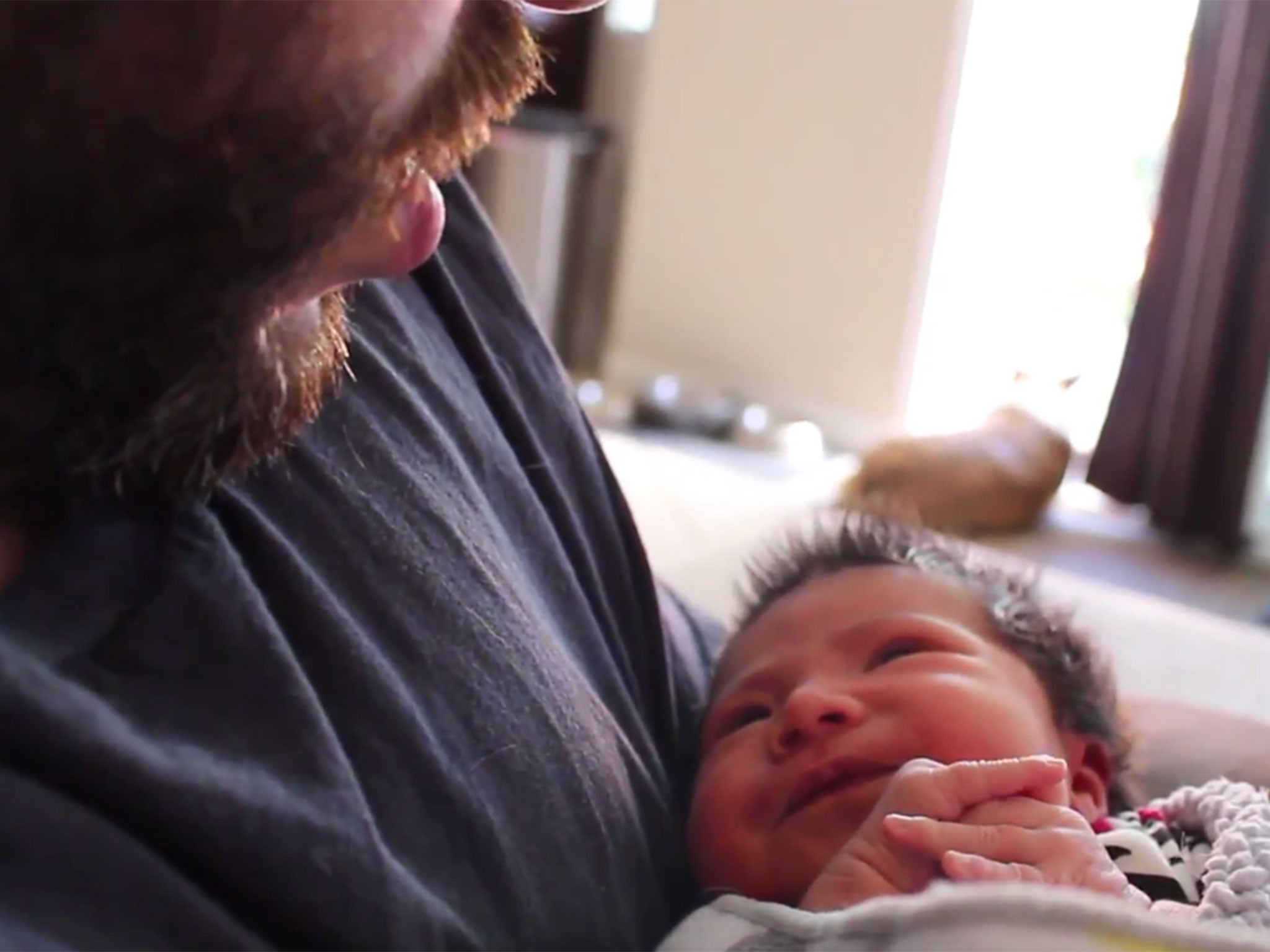 A father soothes his baby by mimicking Darth Vader