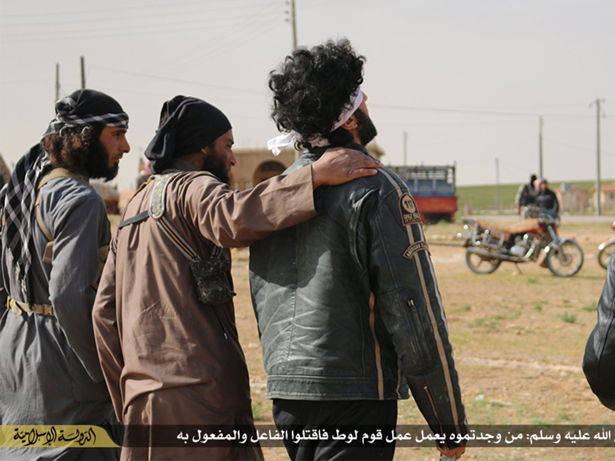 A blindfolded man is lead by militants