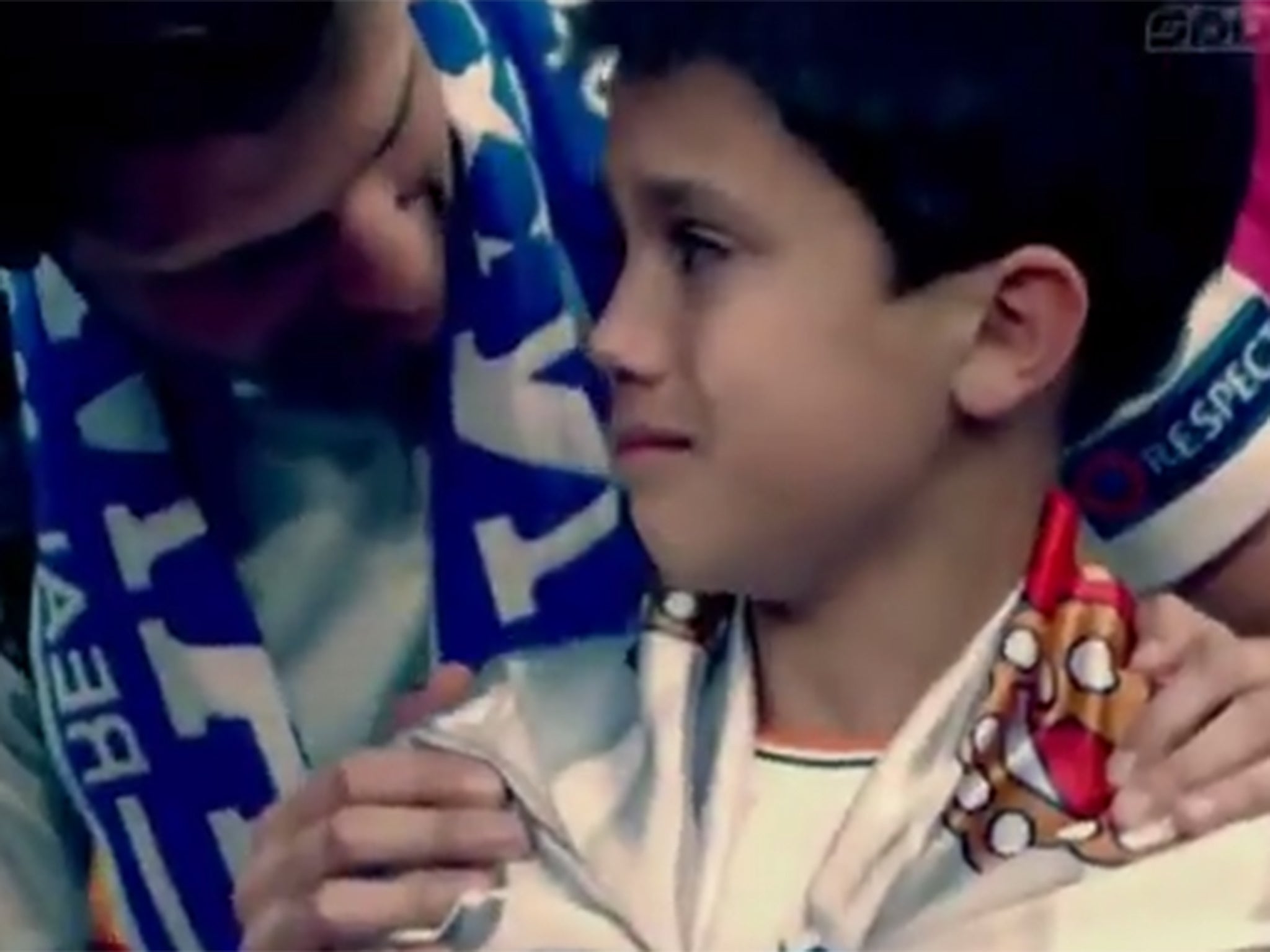 A young fan in tears after being hit in the face by a wayward Cristiano Ronaldo shot