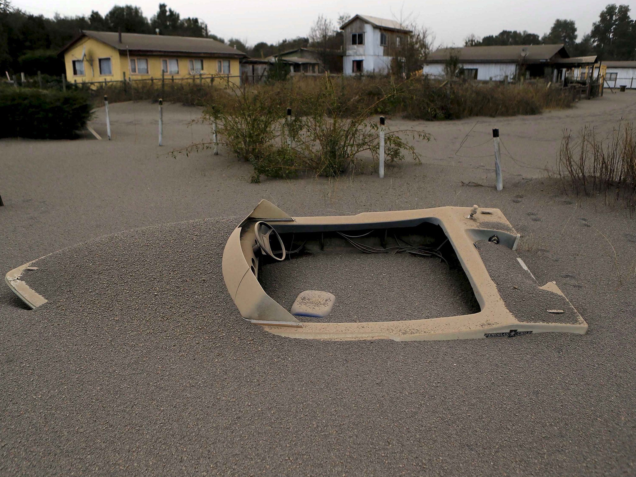 A boat is seen in a house backyard at Ensenada town which is covered with ash from Calbuco volcano near Puerto Varas city