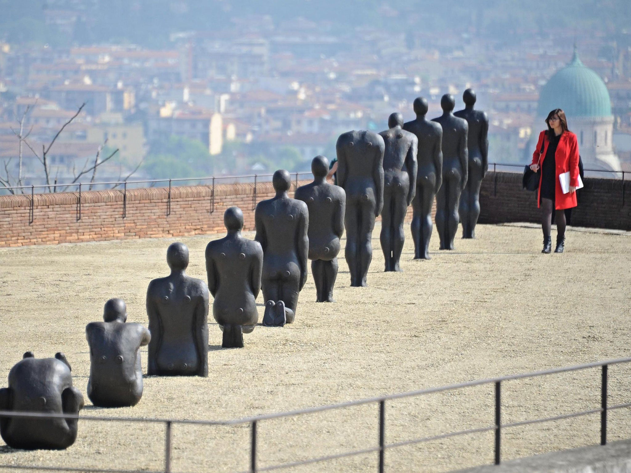 A woman looks at sculptures that are part of the exhibition 'Human' by British artist Antony Gormley at Forte di Belvedere in Florence, Italy. More than 100 scultures will be on display from 26 April to 27 September