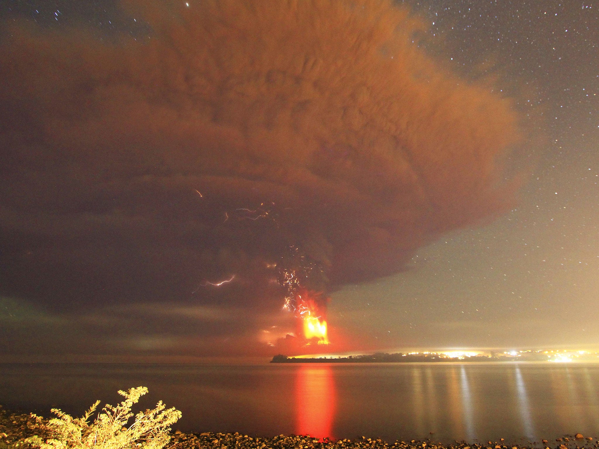 Smoke and lava spew from the Calbuco volcano, as seen from the shores of Lake Llanquihue in Puerto Varas