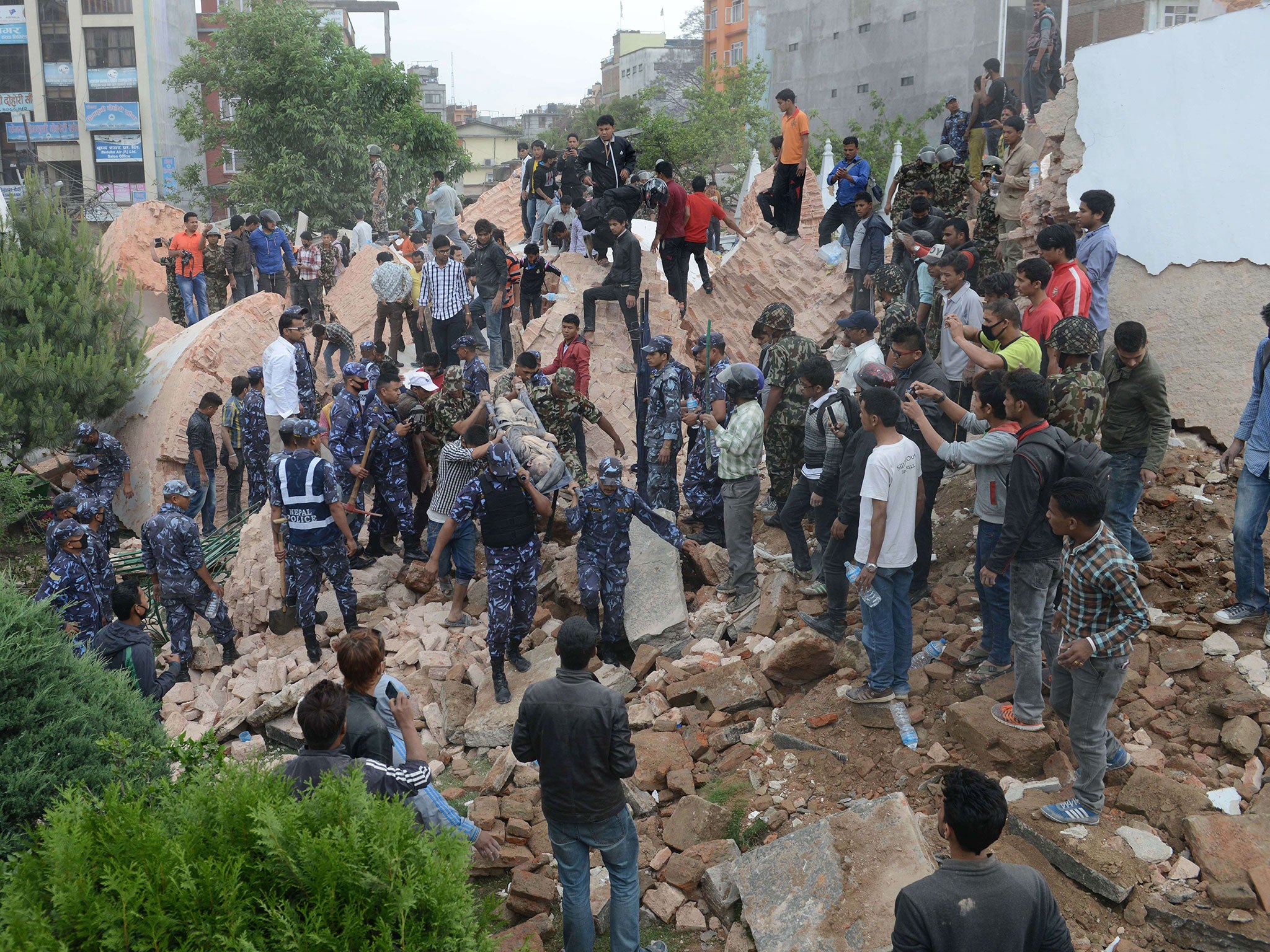 Nepalese rescue members move the body of a victim from the collapsed Darahara Tower in Kathmandu