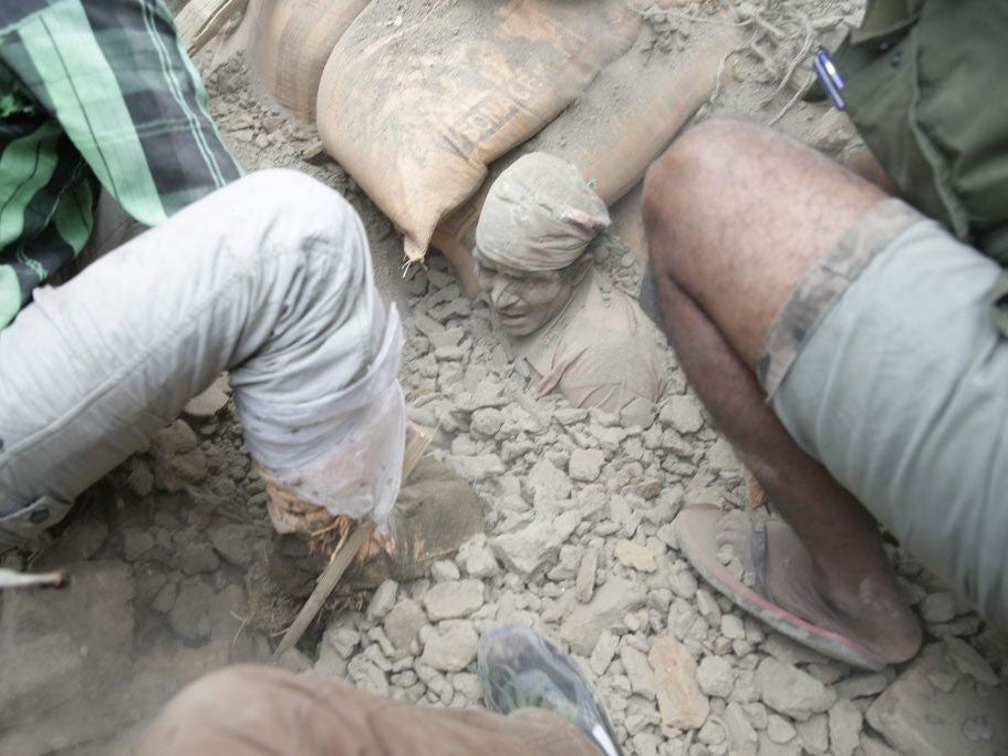 People try to free a living man from the rubble of a destroyed building after an earthquake hit Nepal