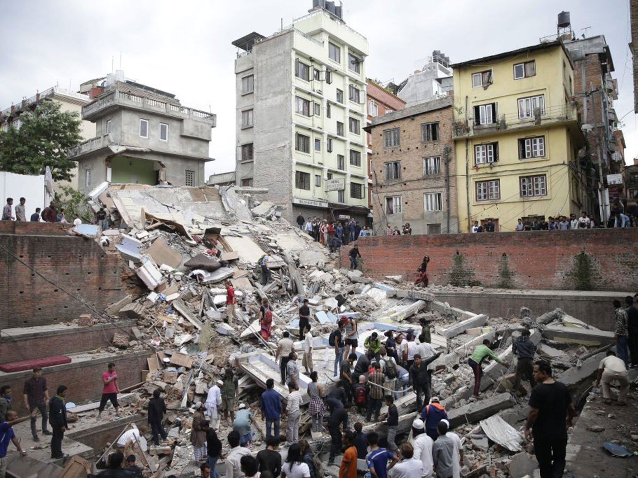 People search for survivors stuck under the rubble of a destroyed building